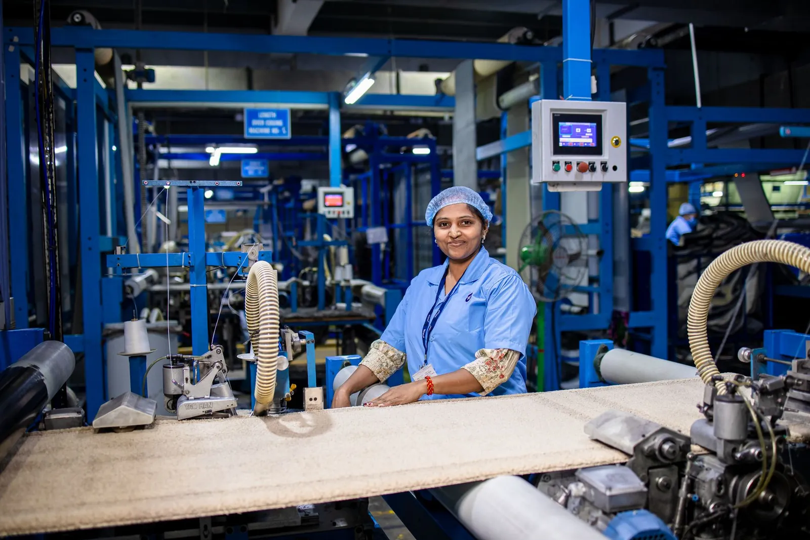 Smiling female worker in a modern textile factory, showcasing the industrial workspace. Stock photo illustrating Accretion Nutraveda's financial results story.