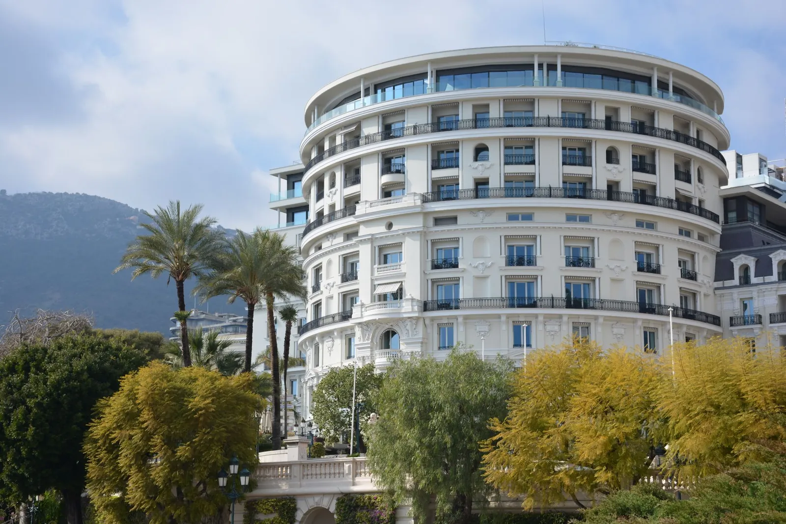 Luxurious round hotel with palm trees, offering an elegant getaway. Stock photo illustrating Juniper Hotels' expansion story.