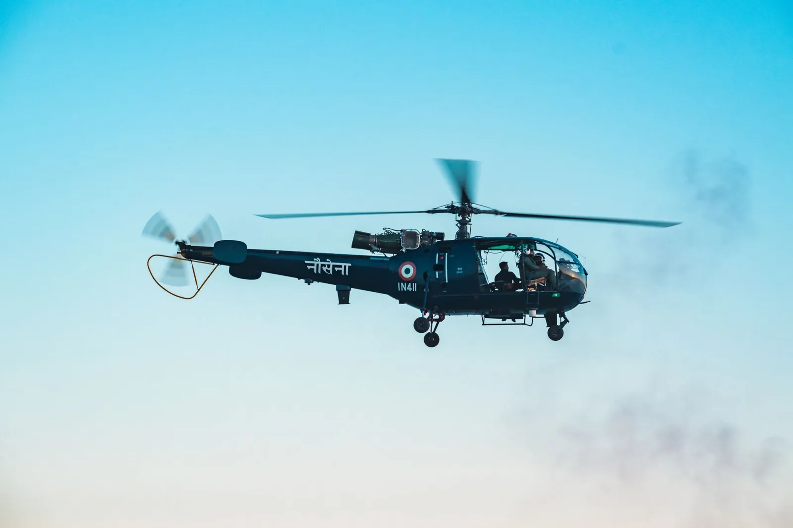 A military helicopter from the Indian Navy flying over a clear blue sky in Visakhapatnam, India. Stock photo illustrating Bharat Dynamics' new order story.