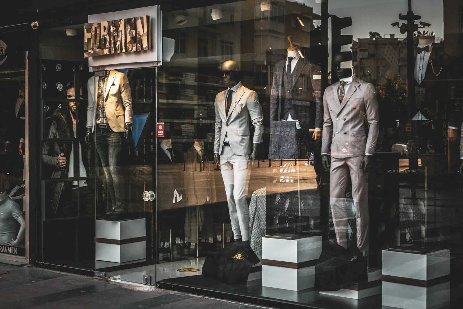 Stylish men's suits on mannequins in a boutique window display. Perfect for fashion and retail themes. Stock photo illustrating Thomas Scott (India)'s earning call story.