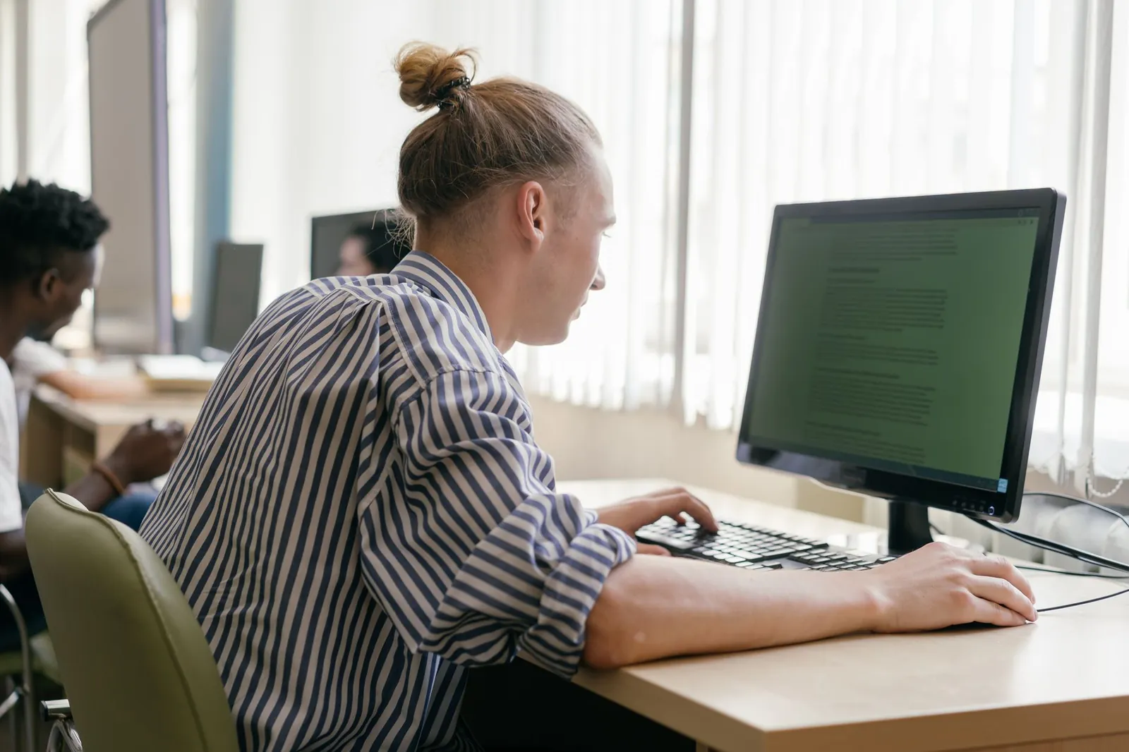 Focused student working on a computer in a bright, modern study space. Stock photo illustrating NIIT's product launched story.