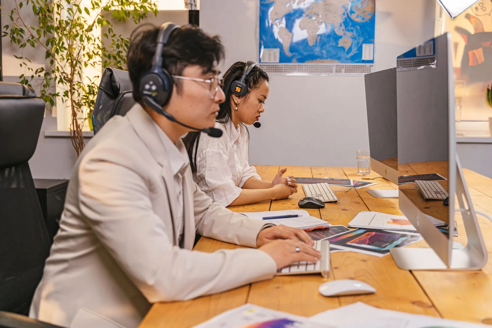 Call center agents working at computers with headsets in a modern office setting. Stock photo illustrating One Point One Solutions' earning call story.
