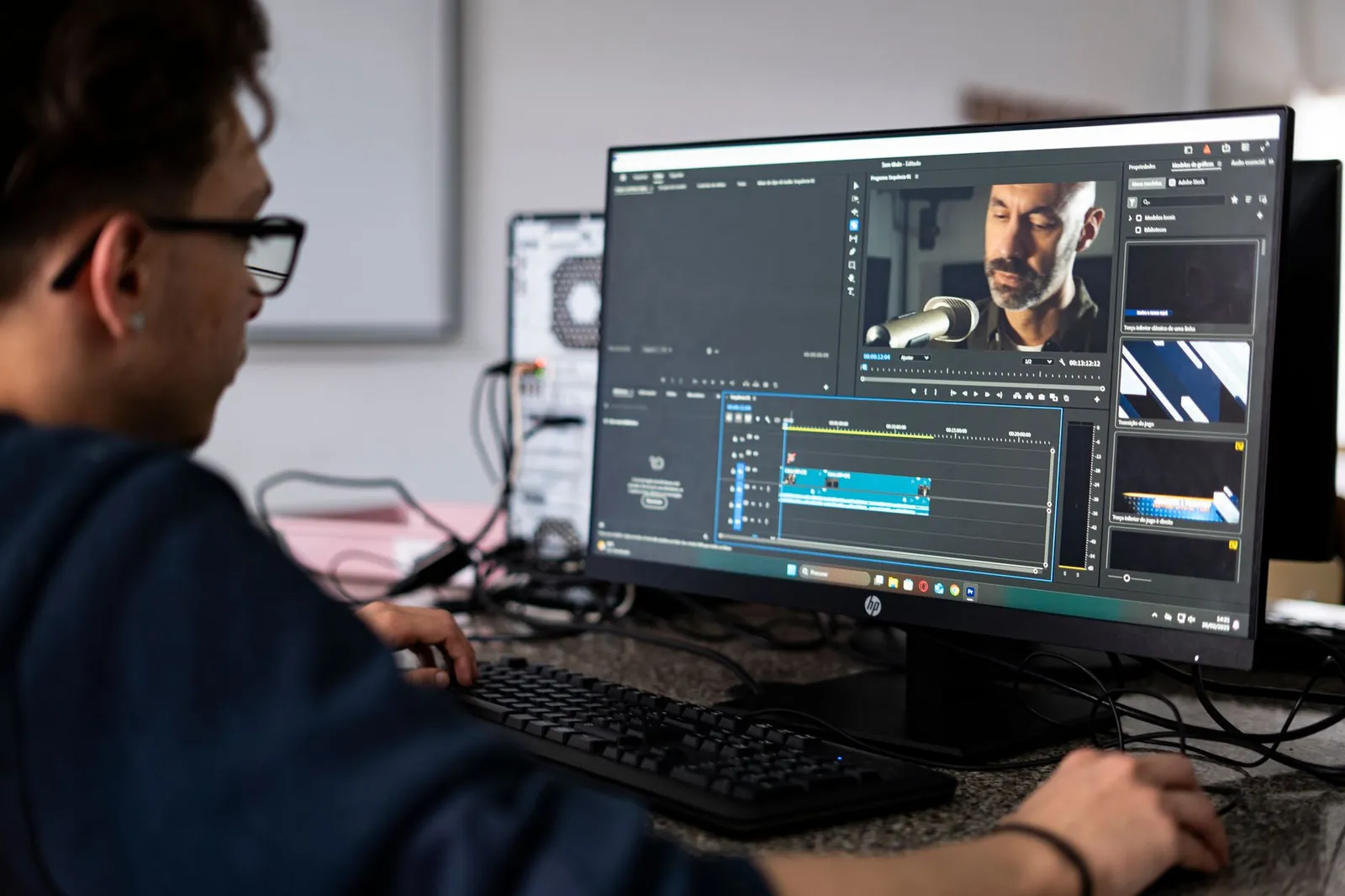 A video editor working on a project using a desktop computer in a modern office setting. Stock photo illustrating Vertoz's fund raise story.