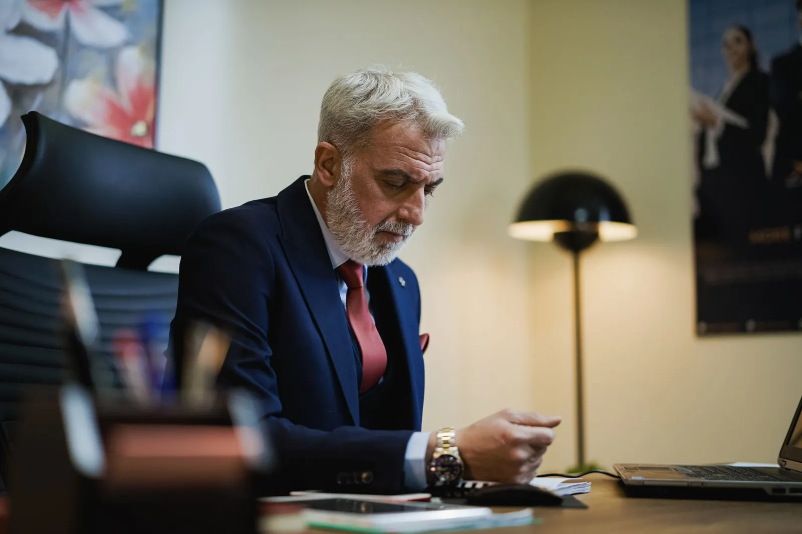 Senior businessman in formal attire working at his office desk with focused expression. Stock photo illustrating Motilal Oswal Financial Services' regulatory approval story.