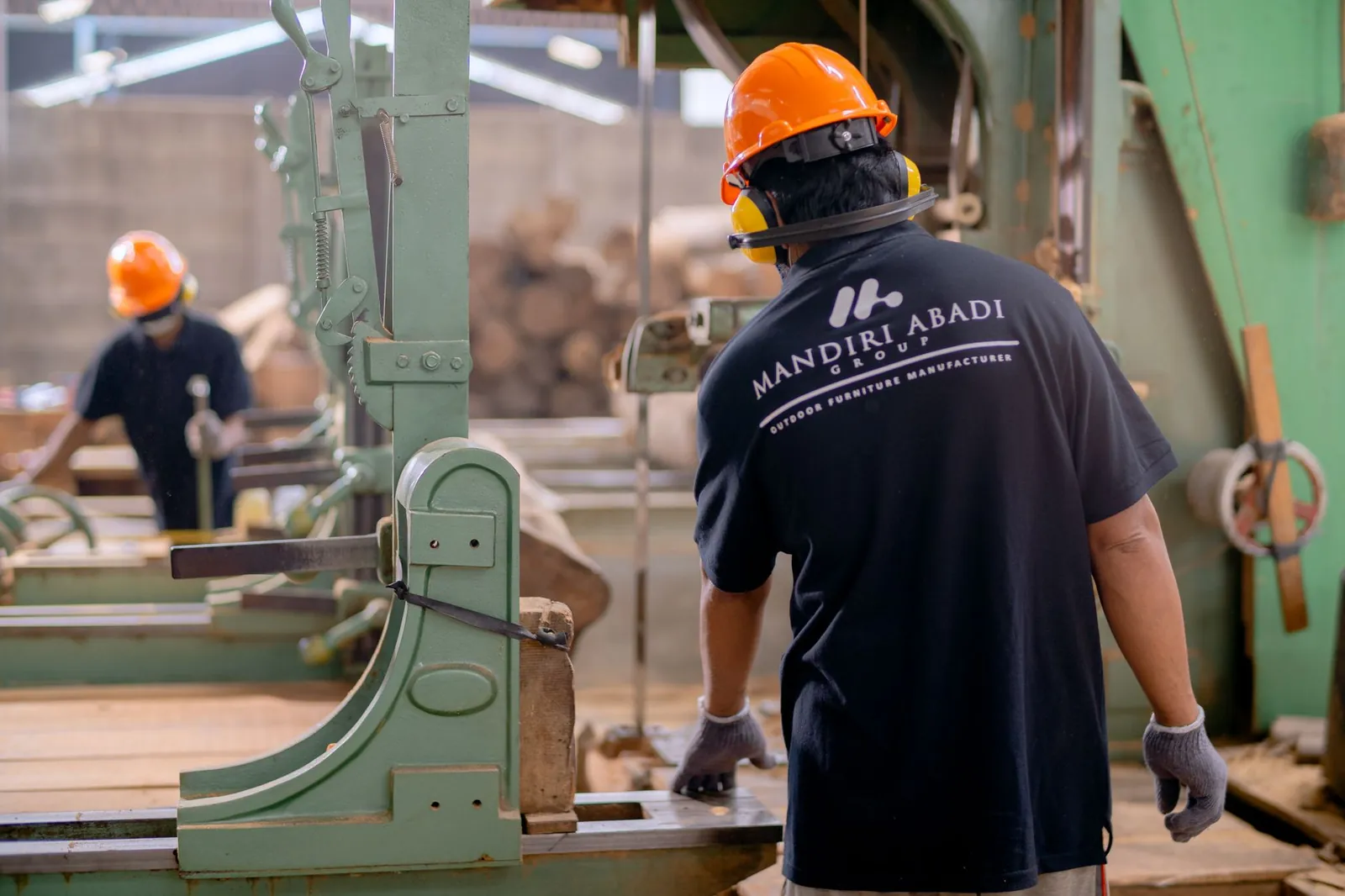 Workers wearing protective gear operating machinery in a factory environment, focusing on safety and production. Stock photo illustrating MMP Industries' fund raise story.