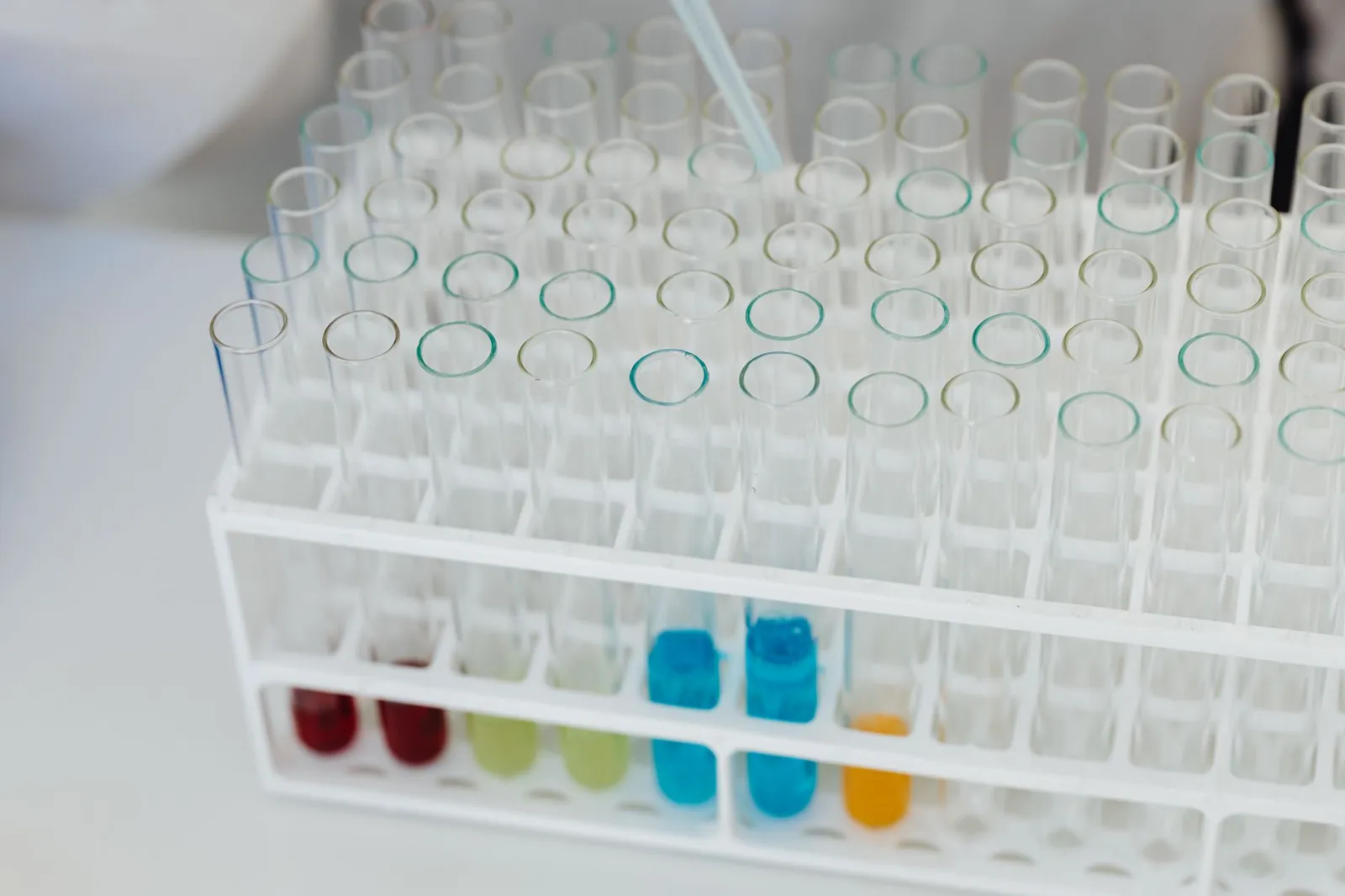 Close-up of a laboratory test tube rack with colorful chemical solutions, emphasizing scientific research. Stock photo illustrating Wanbury's product launched story.