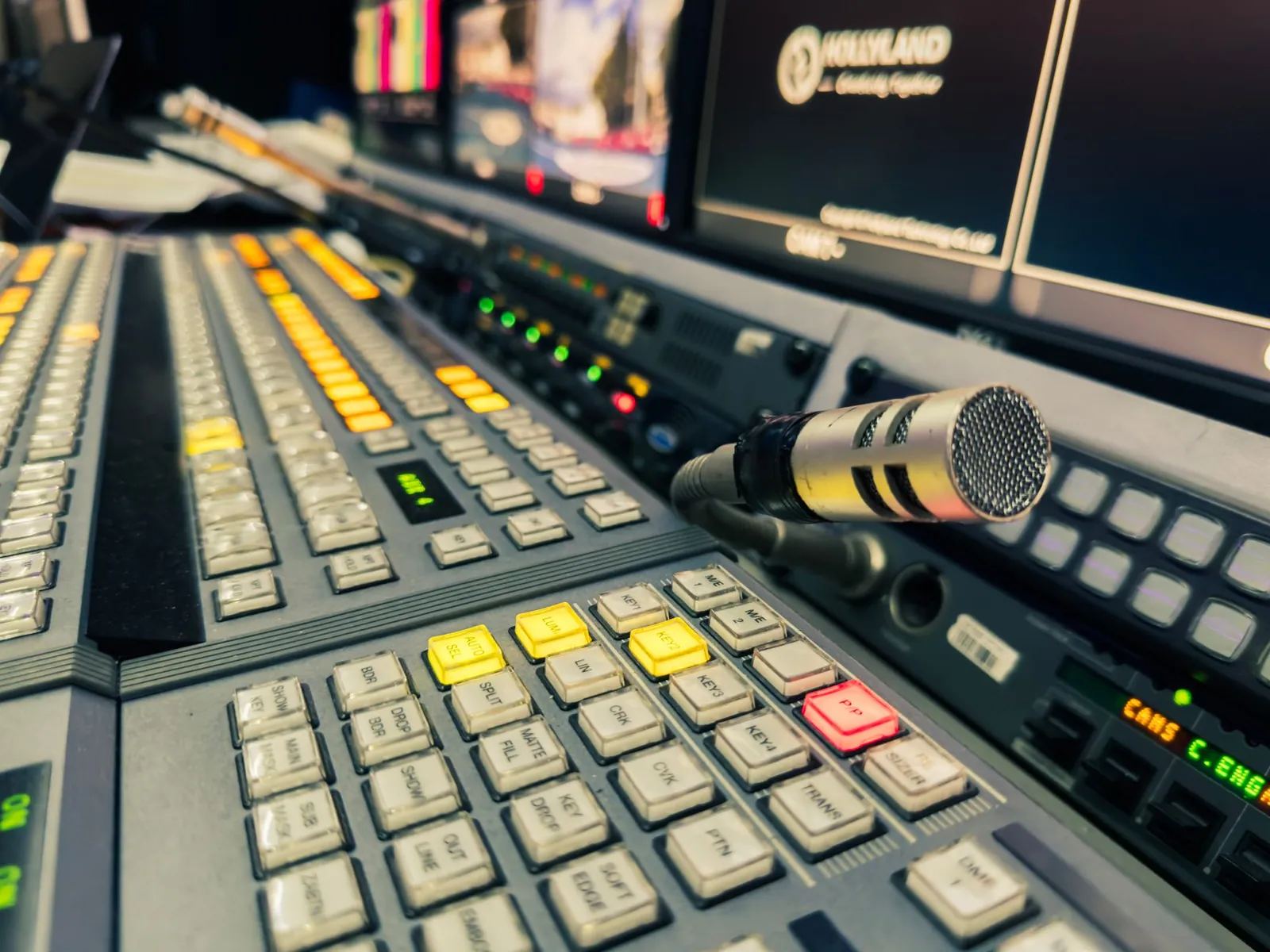 Detailed view of a broadcasting studio control panel with a microphone and multiple screens. Stock photo illustrating Bodhi Tree Multimedia's earning call story.