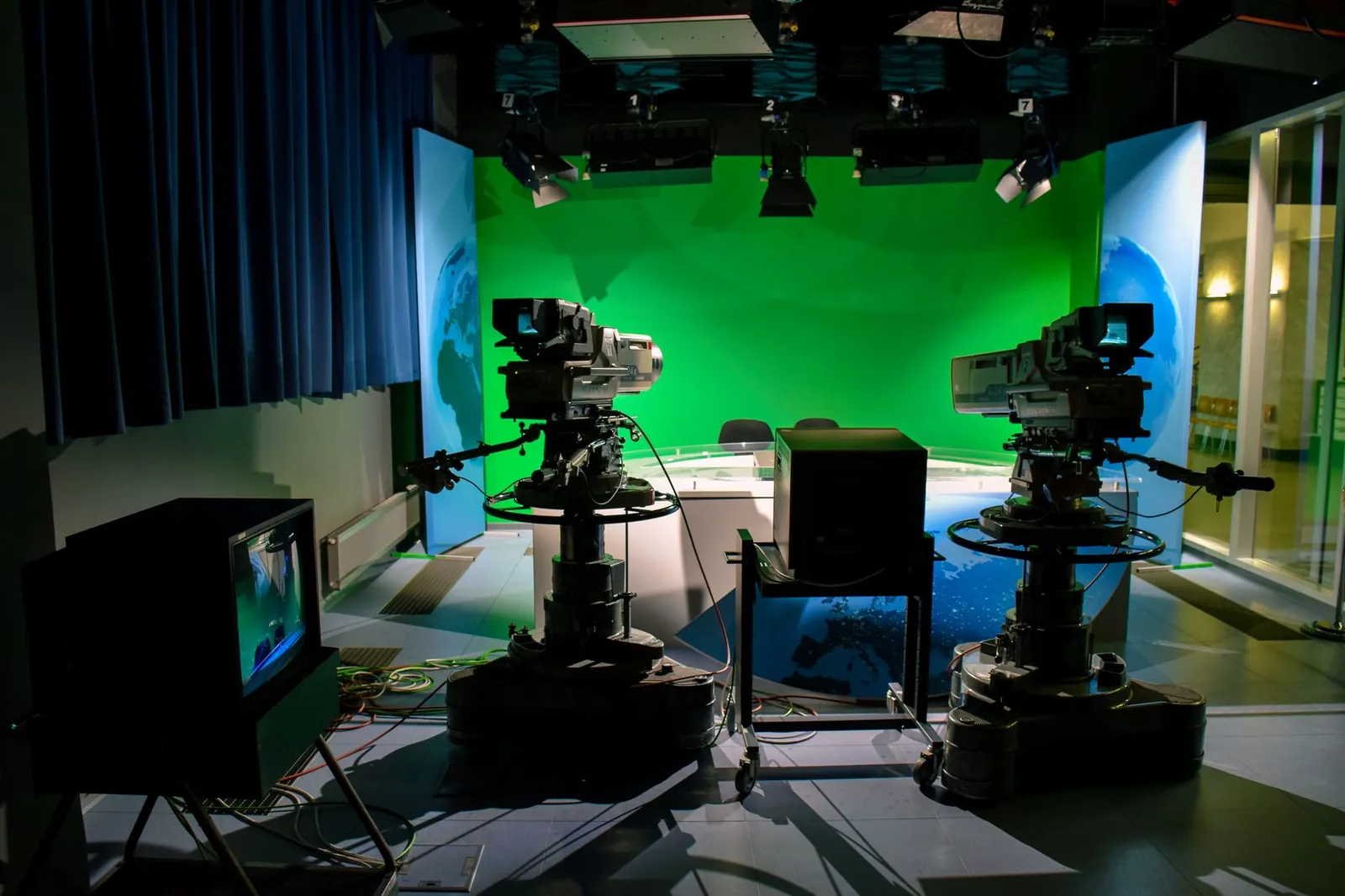 A TV studio setup featuring cameras and a green screen for production purposes. Stock photo illustrating Bodhi Tree Multimedia's fund raise story.