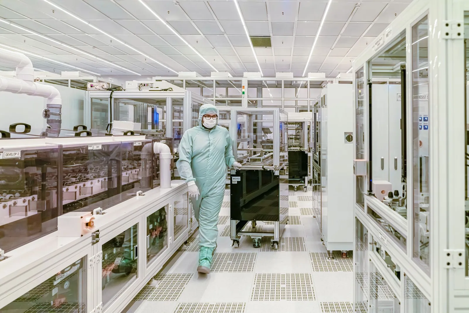 Scientist in protective gear walking in a high-tech cleanroom laboratory environment. Stock photo illustrating Shilpa Medicare's expansion story.