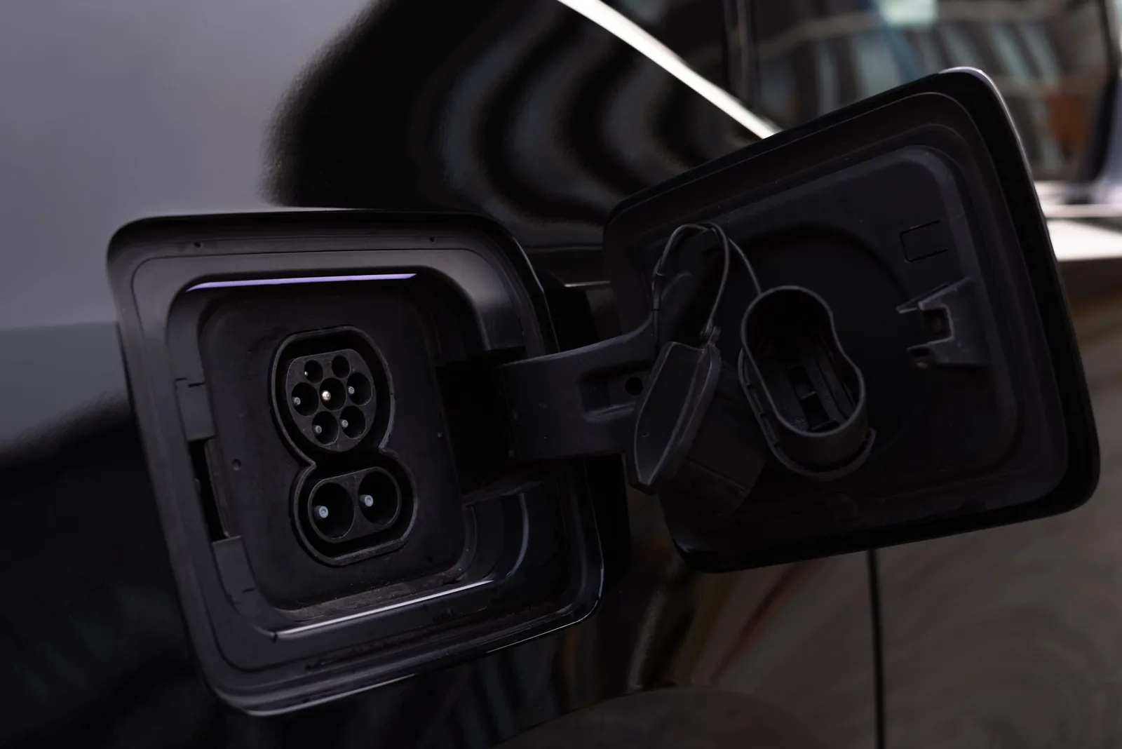 Close-up image of an electric vehicle charging port on a black car. Stock photo illustrating Tata Communications' product launched story.