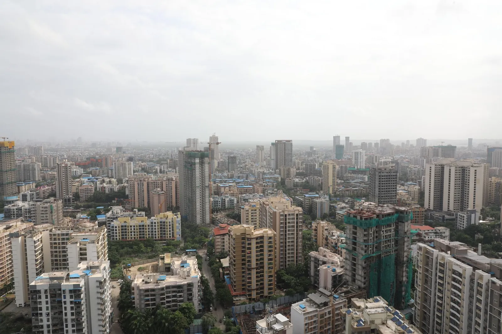 Overhead view of a bustling cityscape with high-rise buildings under a cloudy sky. Stock photo illustrating Mason Infratech's new order story.