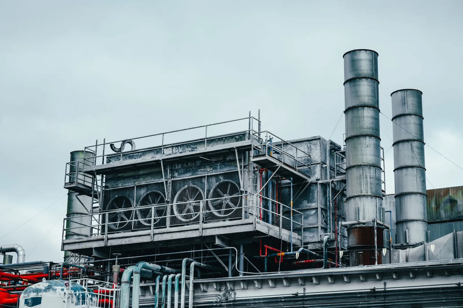 Exterior view of large industrial construction with metal tubes located on factory in daytime on cloudy weather. Stock photo illustrating Ice Make Refrigeration's fund raise story.