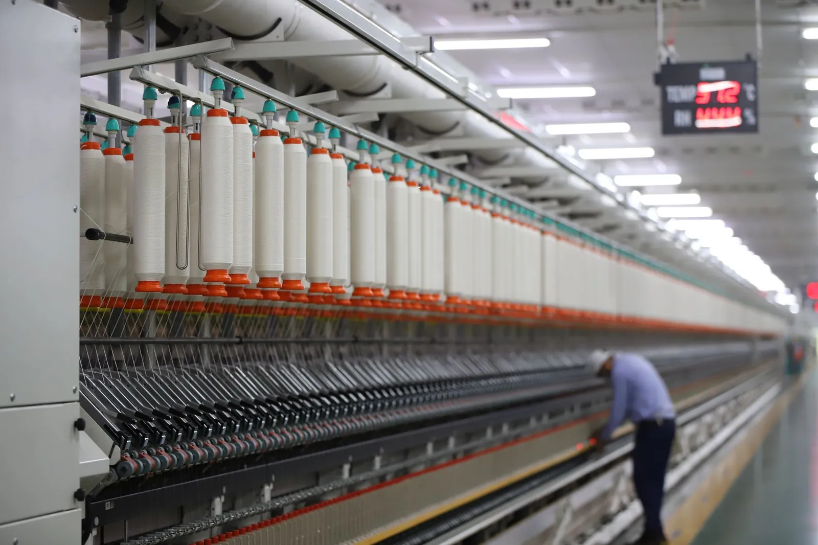 A textile factory in India showcasing modern spinning machinery with a worker. Stock photo illustrating ACS Technologies' fund raise story.