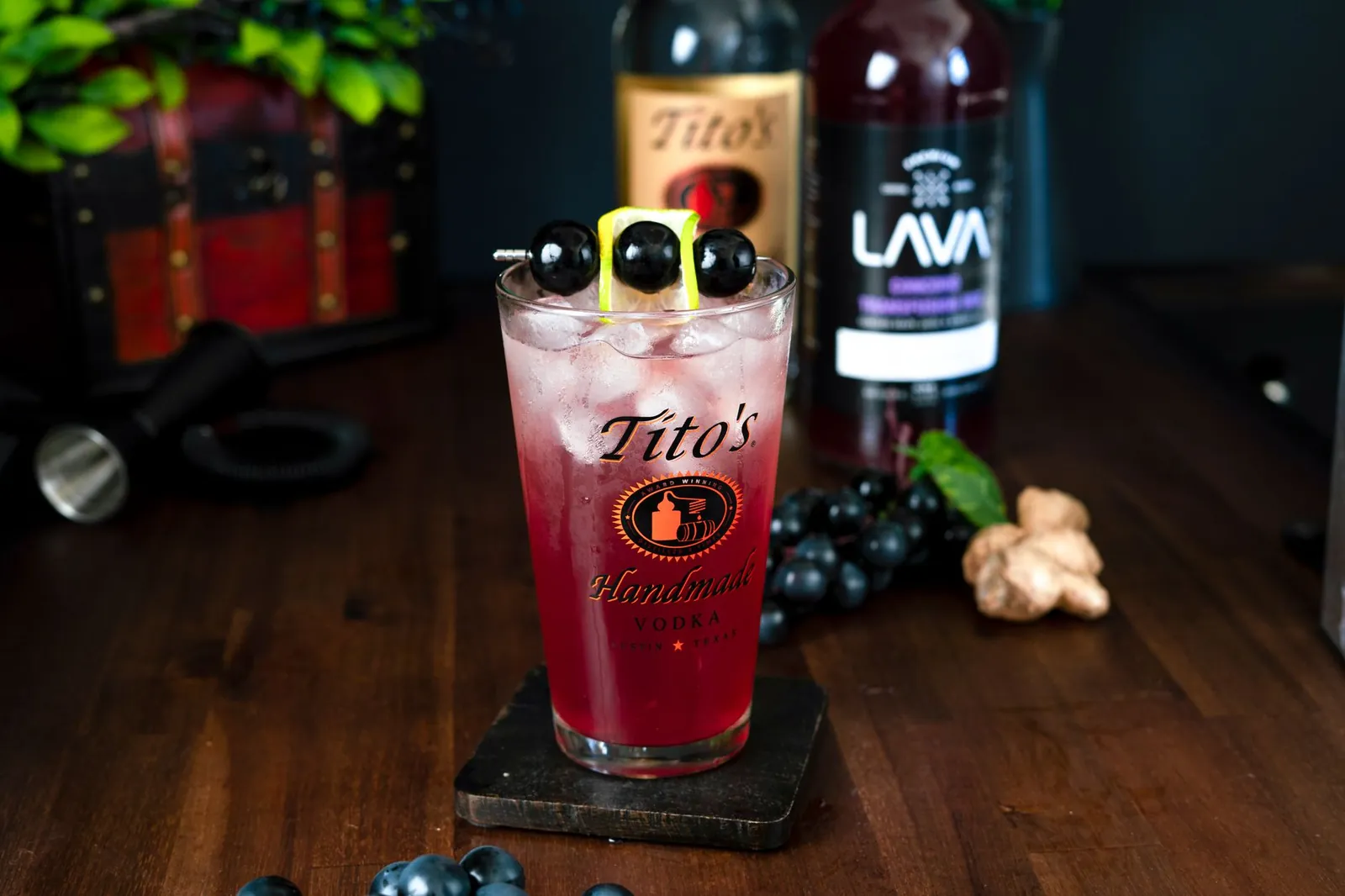 Refreshing fruit cocktail with vodka, garnished with grapes and lemon slice, served with ice in an elegant glass. Stock photo illustrating Radico Khaitan's product launched story.