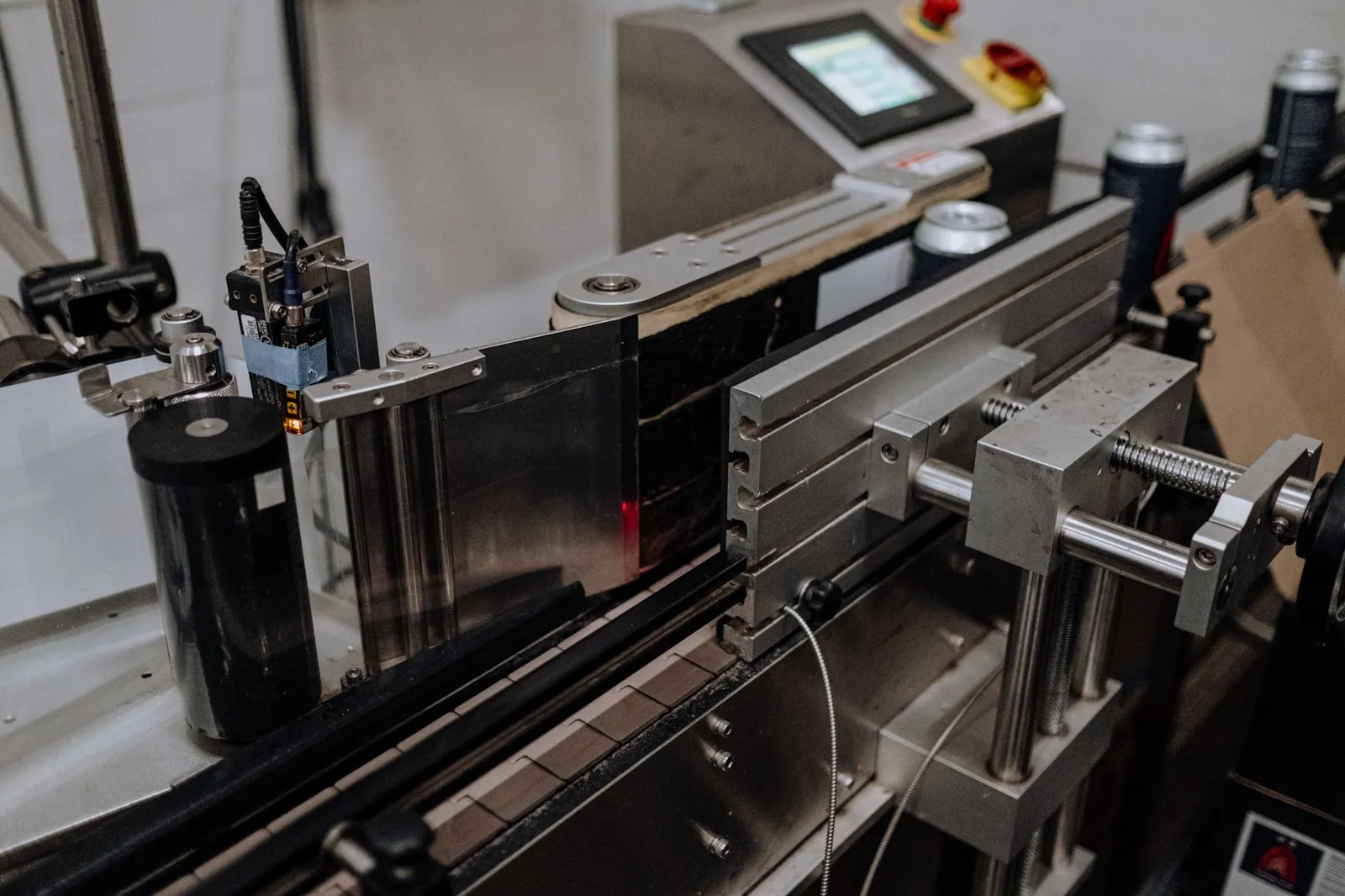 Close-up of automated canning equipment in a modern brewery assembly line. Stock photo illustrating Syrma SGS Technology's earning call story.