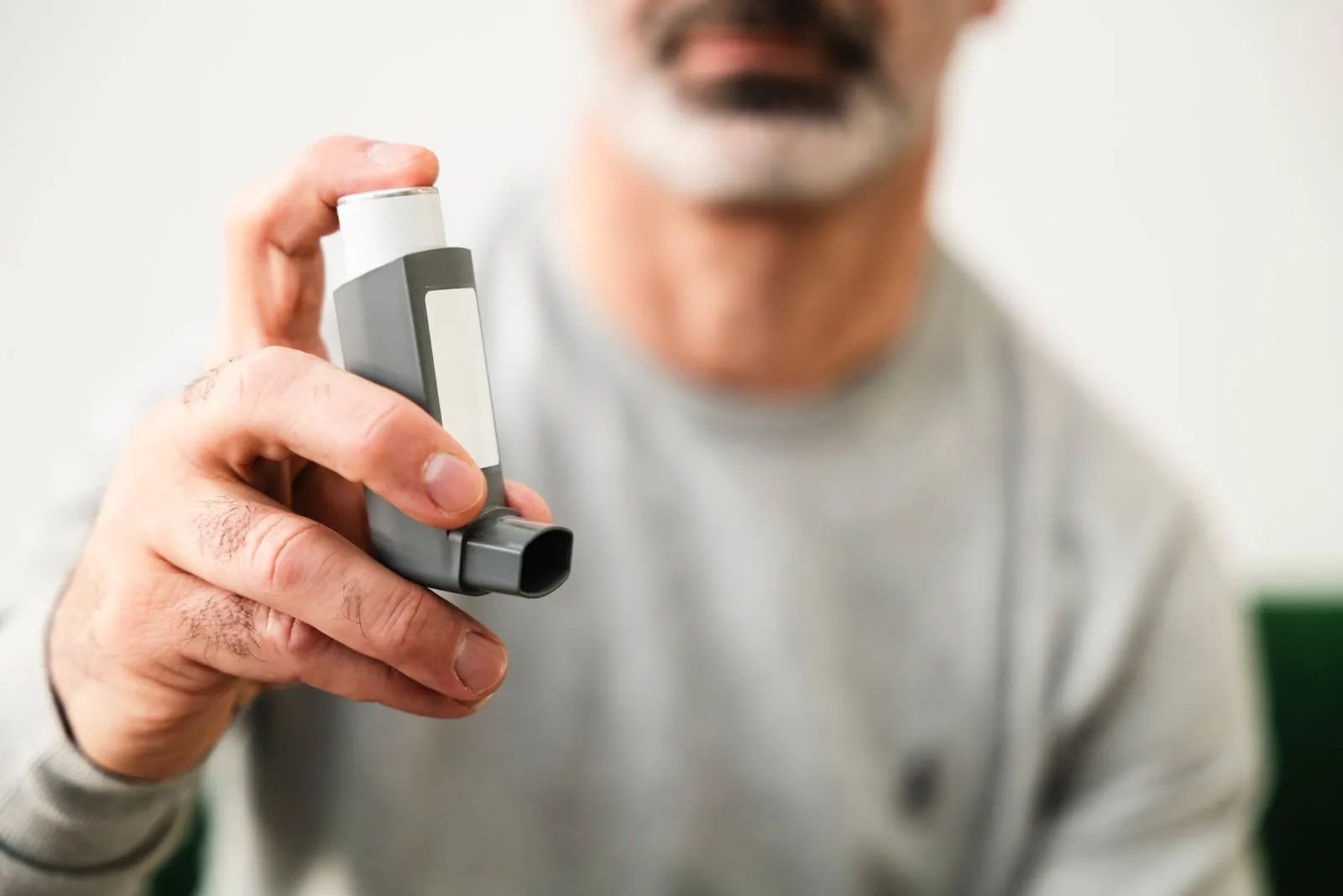 Man using an inhaler for respiratory health indoors. Stock photo illustrating Lupin's product launched story.