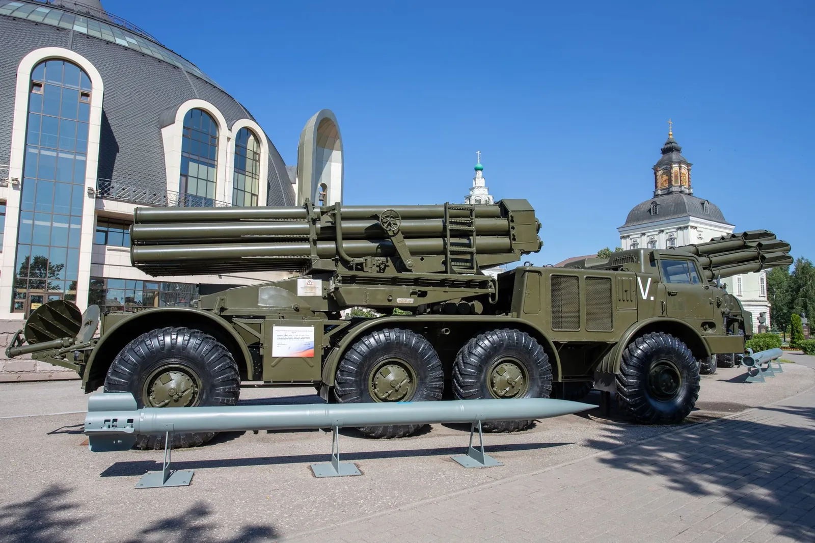 A military missile launcher on exhibit outdoors with a backdrop of unique architecture and clear blue sky. Stock photo illustrating Premier Explosives' earning call story.