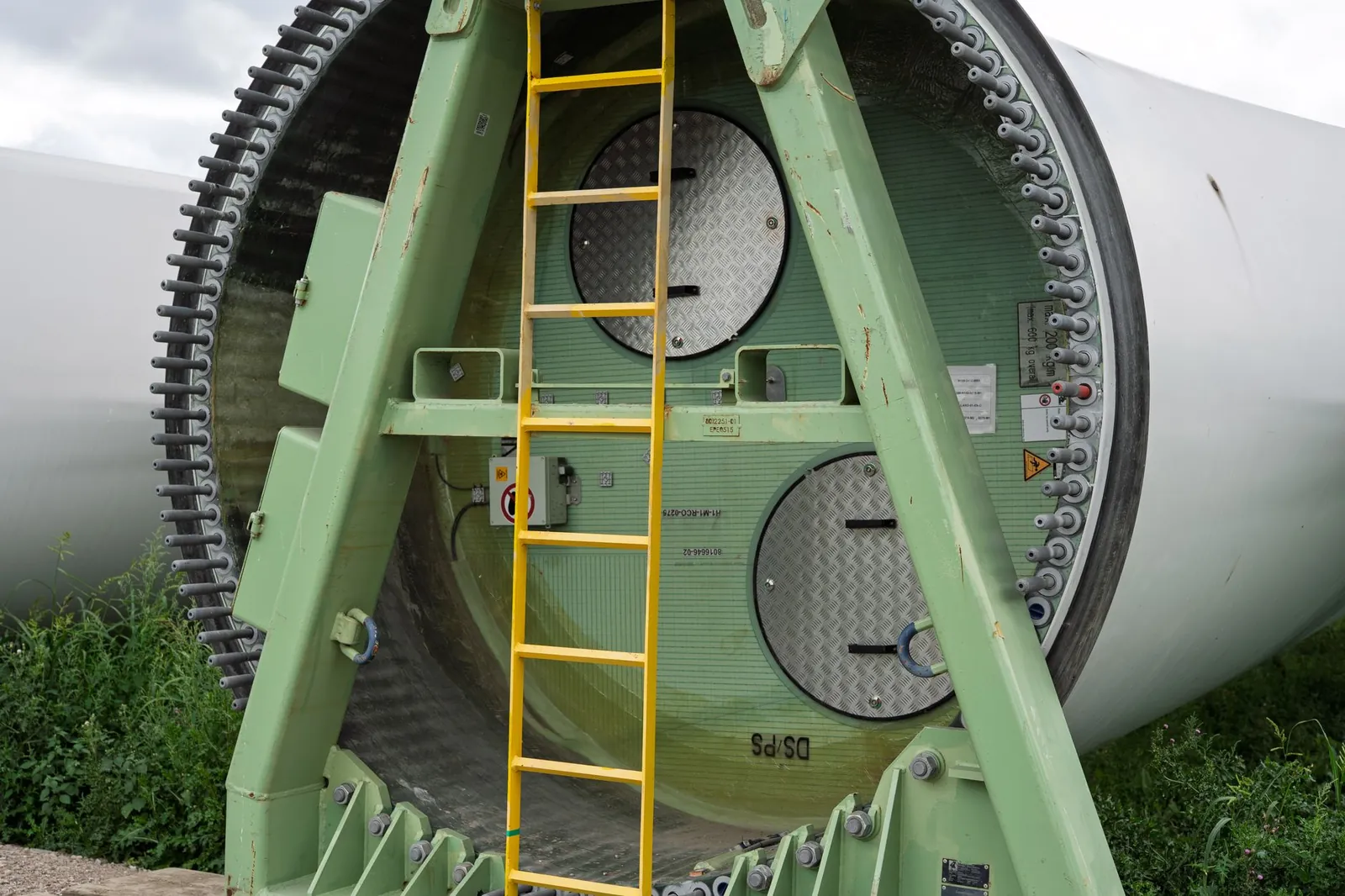 Close-up of a wind turbine section with a ladder attached, showcasing industrial design. Stock photo illustrating Anawil Wire and Engineering's new order story.