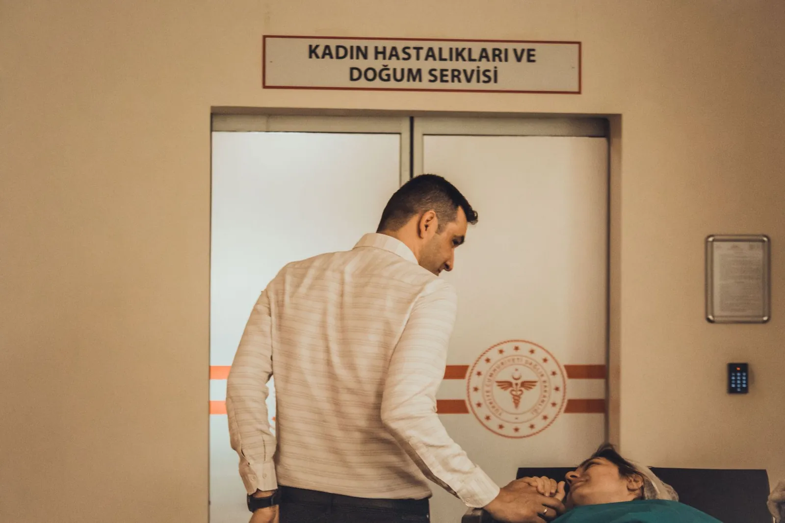 A man supports a woman in the maternity ward of a hospital, holding hands. Stock photo illustrating Jeena Sikho Lifecare's production started story.