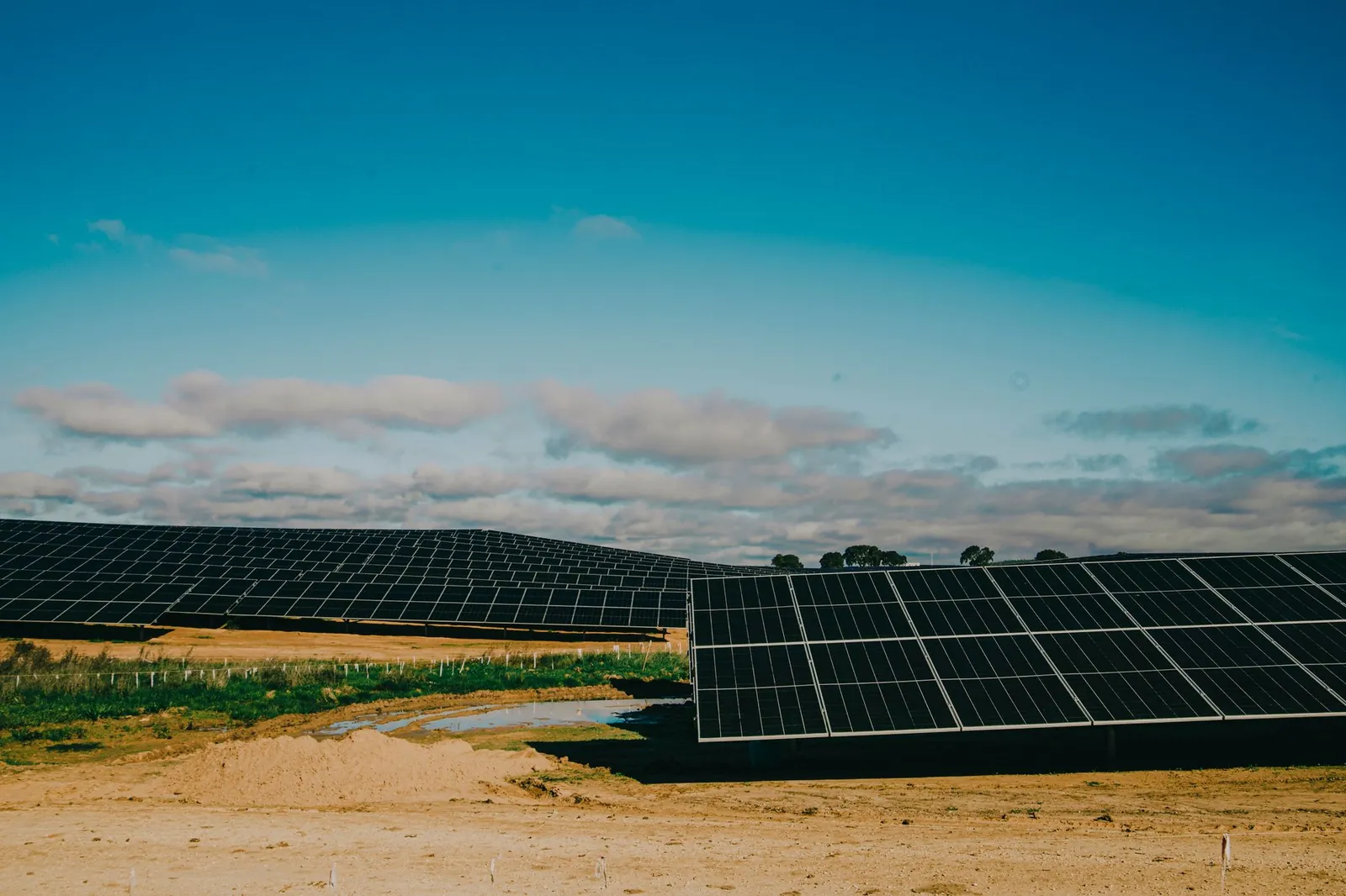 A vast solar farm in a desert setting under clear blue skies, showcasing renewable energy. Stock photo illustrating KPI Green Energy's new order story.