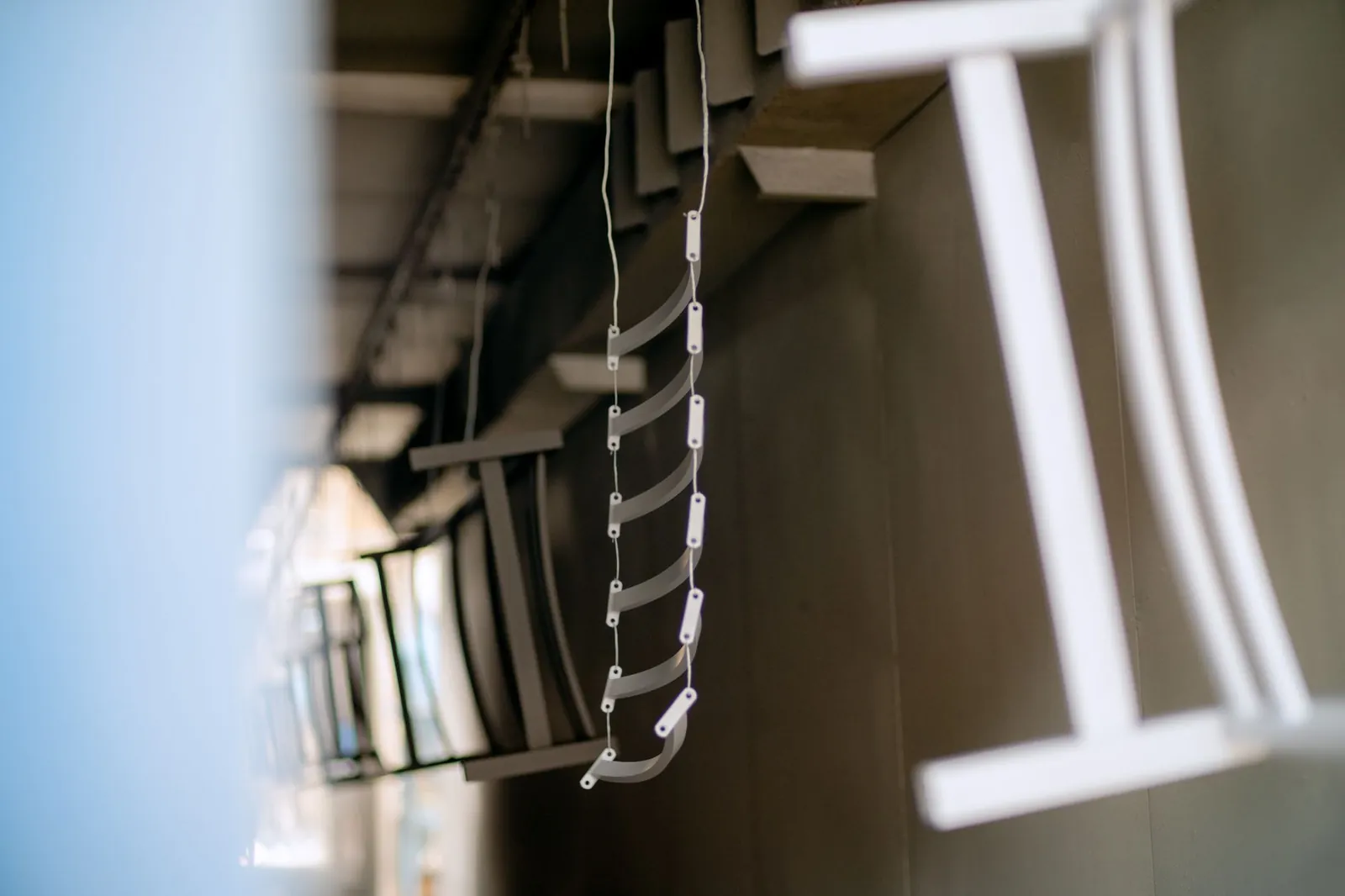 Close-up of industrial metal parts hanging in a coating process, showcasing manufacturing details. Stock photo illustrating BMW Industries' production started story.