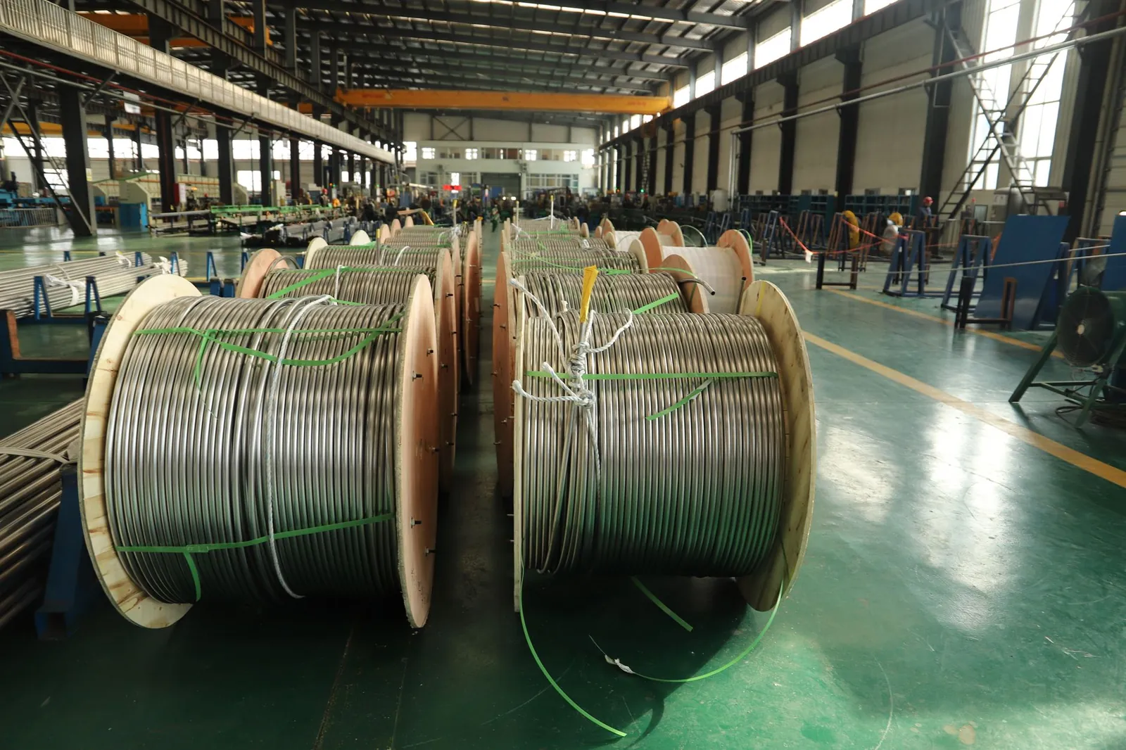 View of large cable reels in an industrial manufacturing facility, showcasing production scale. Stock photo illustrating JD Cables' production started story.