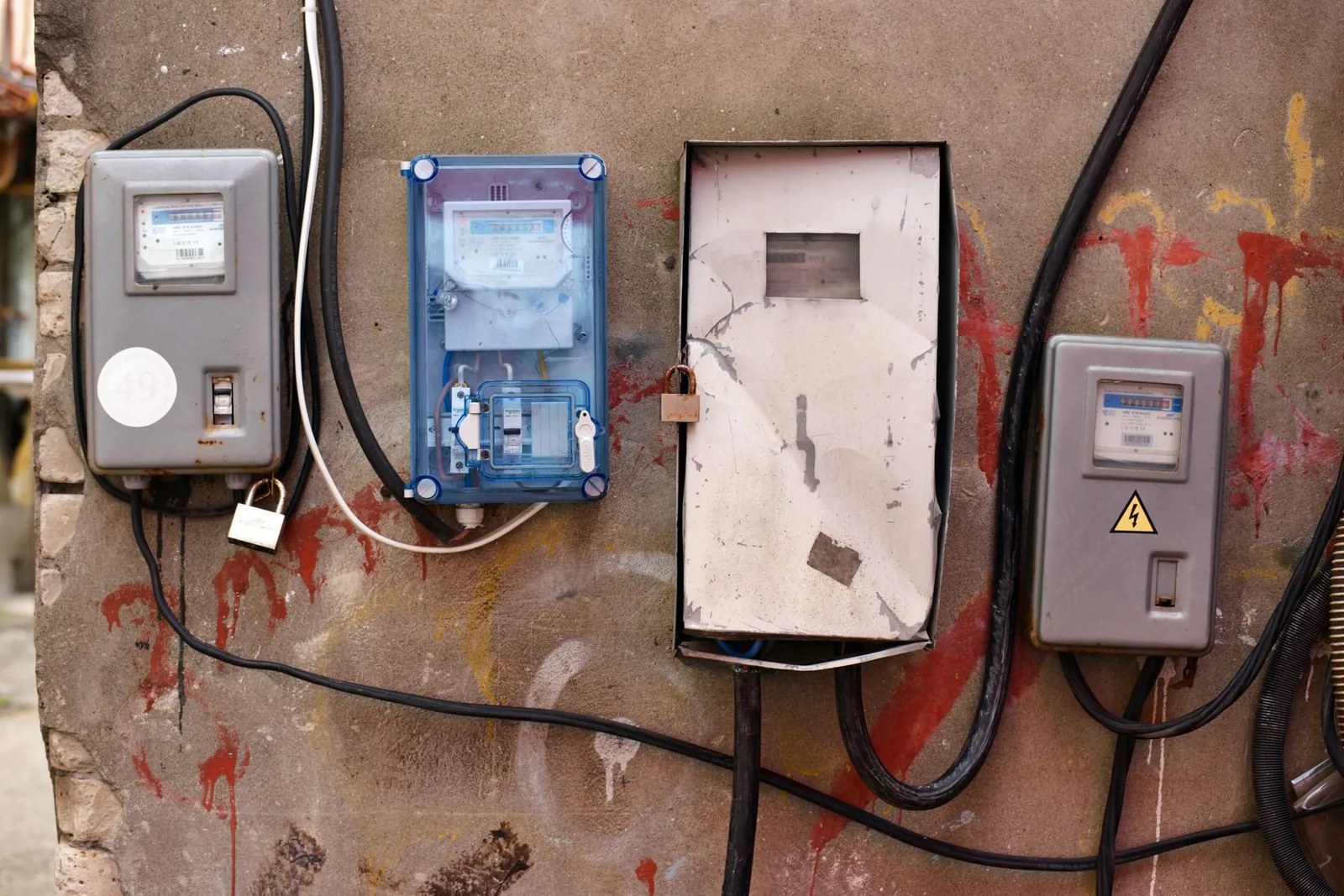 Electrical meters attached to a graffiti-covered wall showcasing utility infrastructure. Stock photo illustrating Axis Solutions' product launched story.