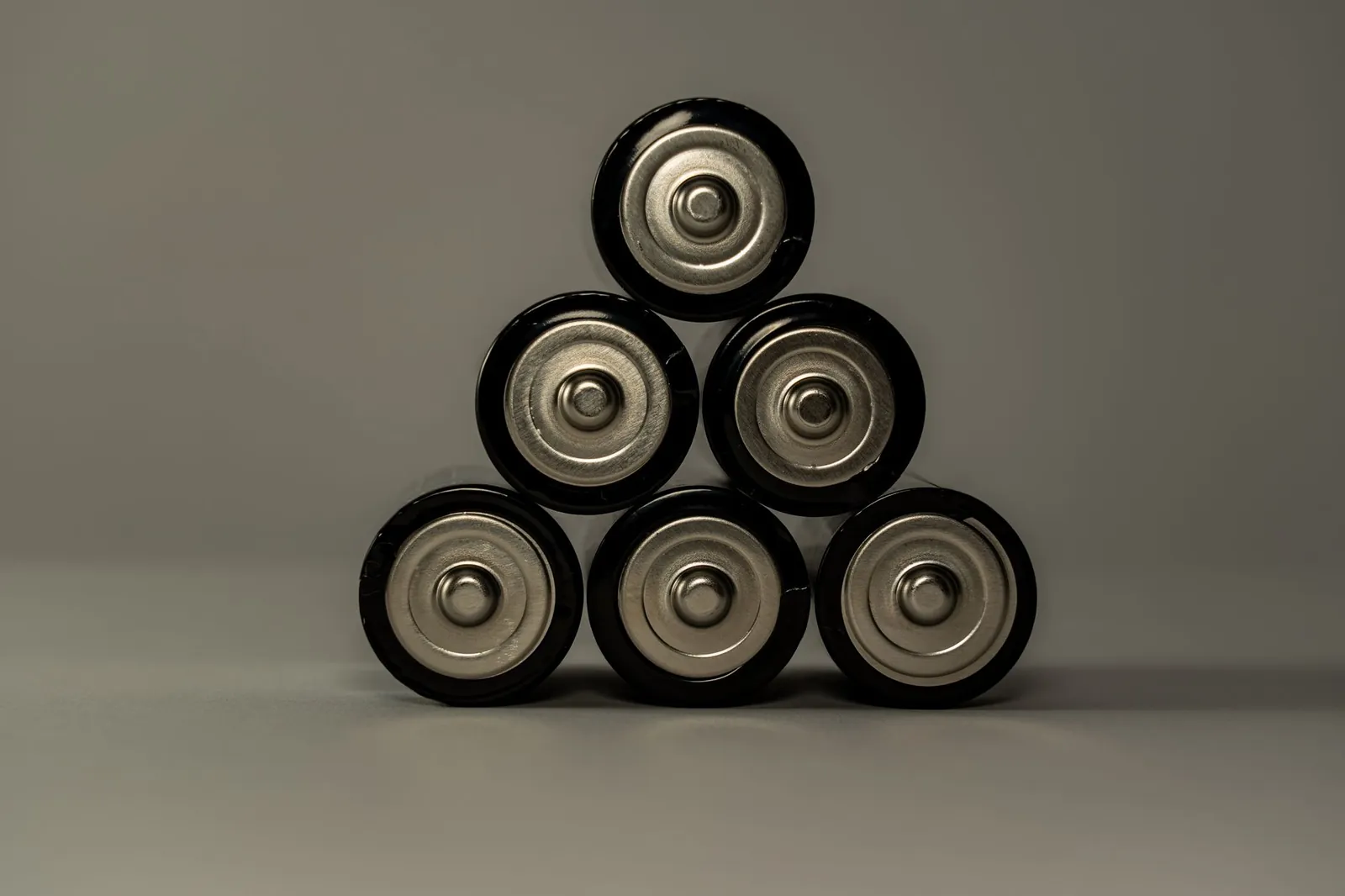 Metallic AA batteries stacked in a pyramid shape, symbolizing power and energy storage. Stock photo illustrating Advait Energy Transitions' partnership story.