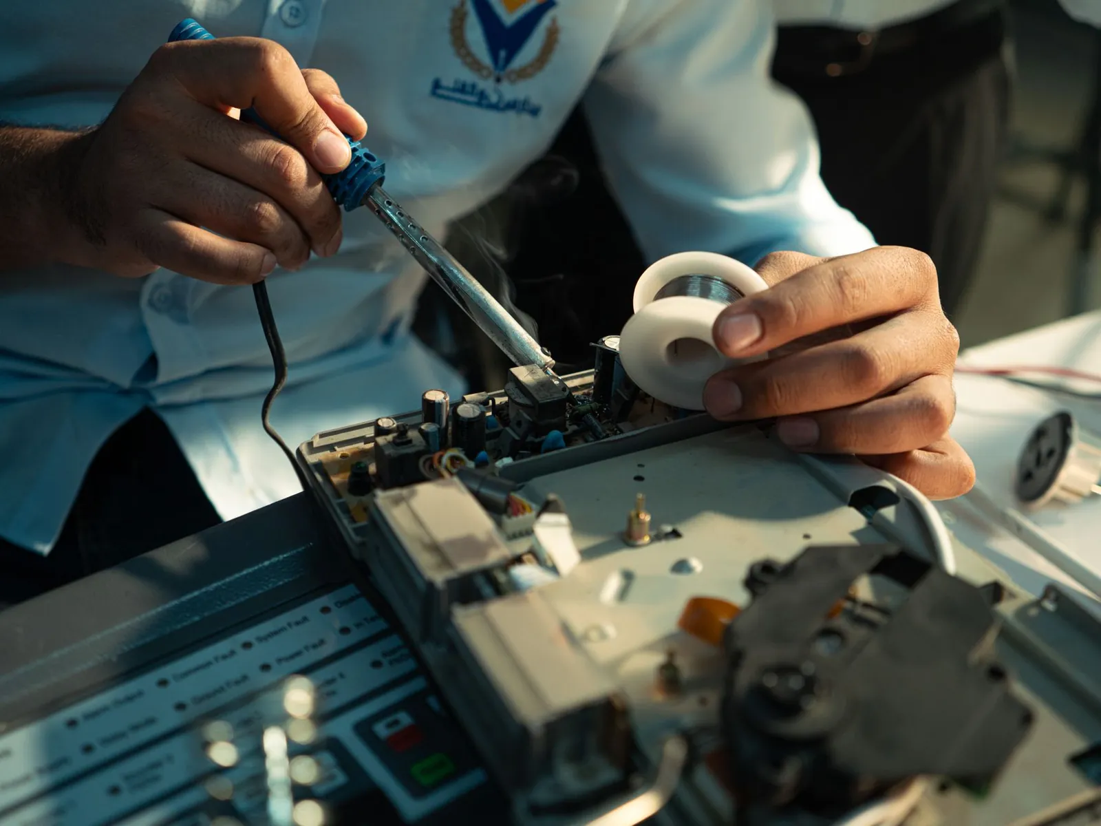 Detailed view of hands soldering an electronic circuit board, showcasing technical skill. Stock photo illustrating Apollo Micro Systems' earning call story.