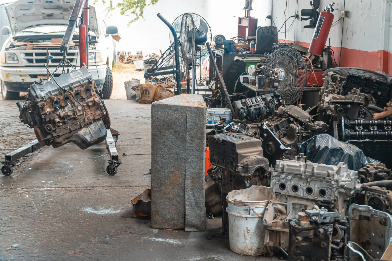 Auto workshop displaying a collection of engine parts and repair equipment. Stock photo illustrating Jullundur Motor Agency (Delhi)'s regulatory approval story.