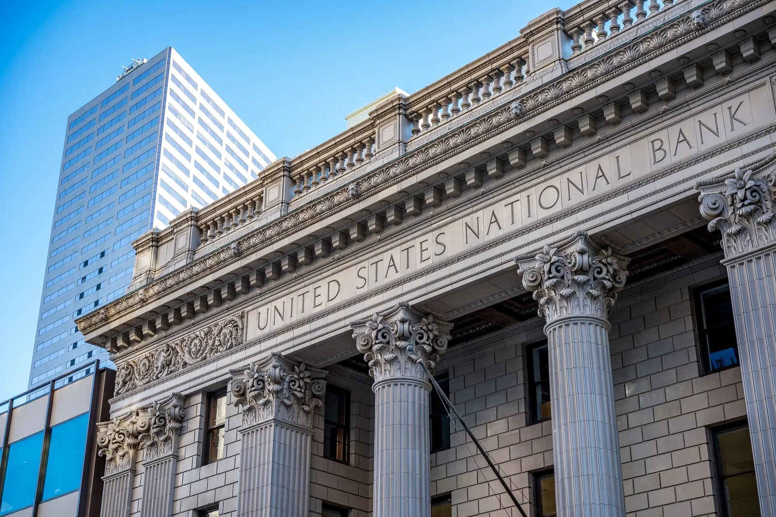 Exterior of historic national bank with decorative elements on classic columns located in city with modern building against blue sky. Stock photo illustrating ICICI Bank's regulatory approval story.