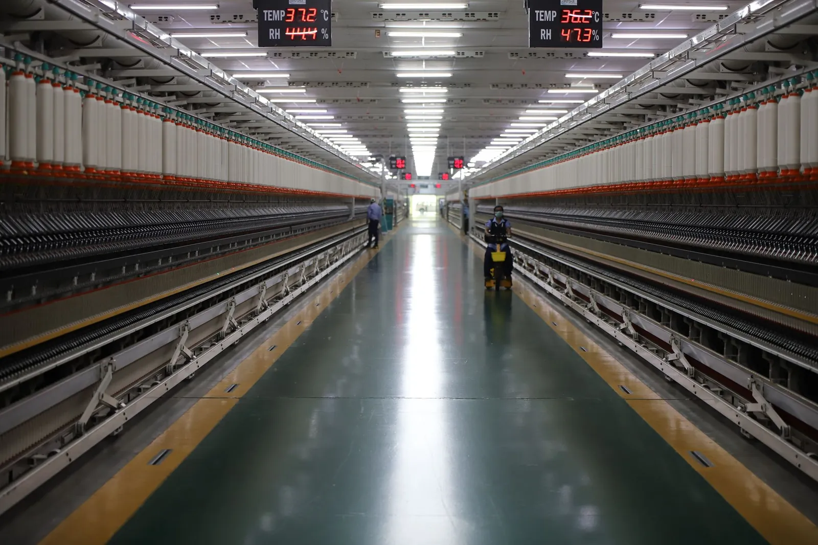 Spacious textile machinery hallway in an Indian industrial plant showing advanced equipment. Stock photo illustrating HFCL's earning call story.