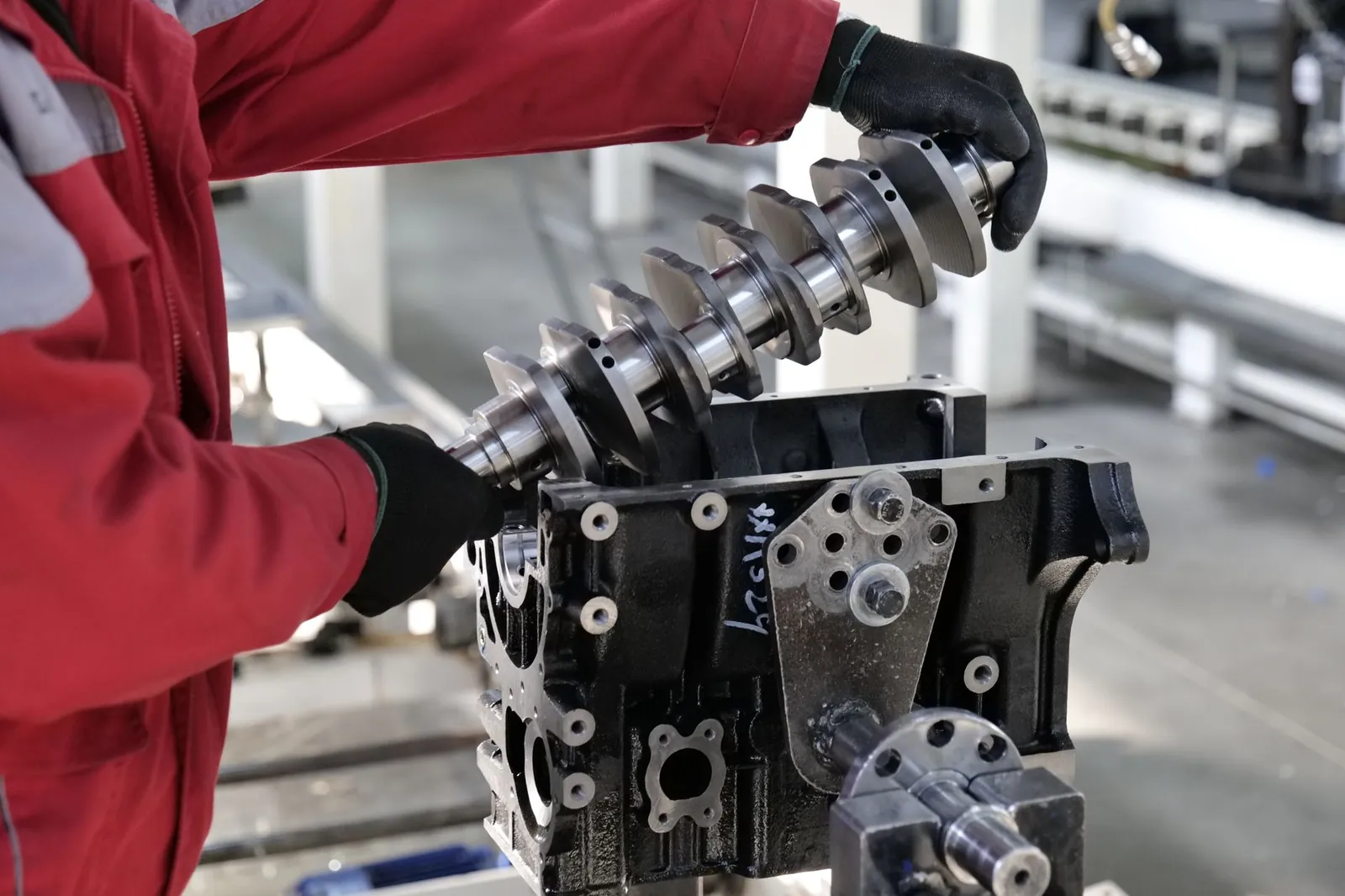 Mechanic working on a crankshaft installation in an engine block in an industrial setting. Stock photo illustrating Greaves Cotton's product launched story.