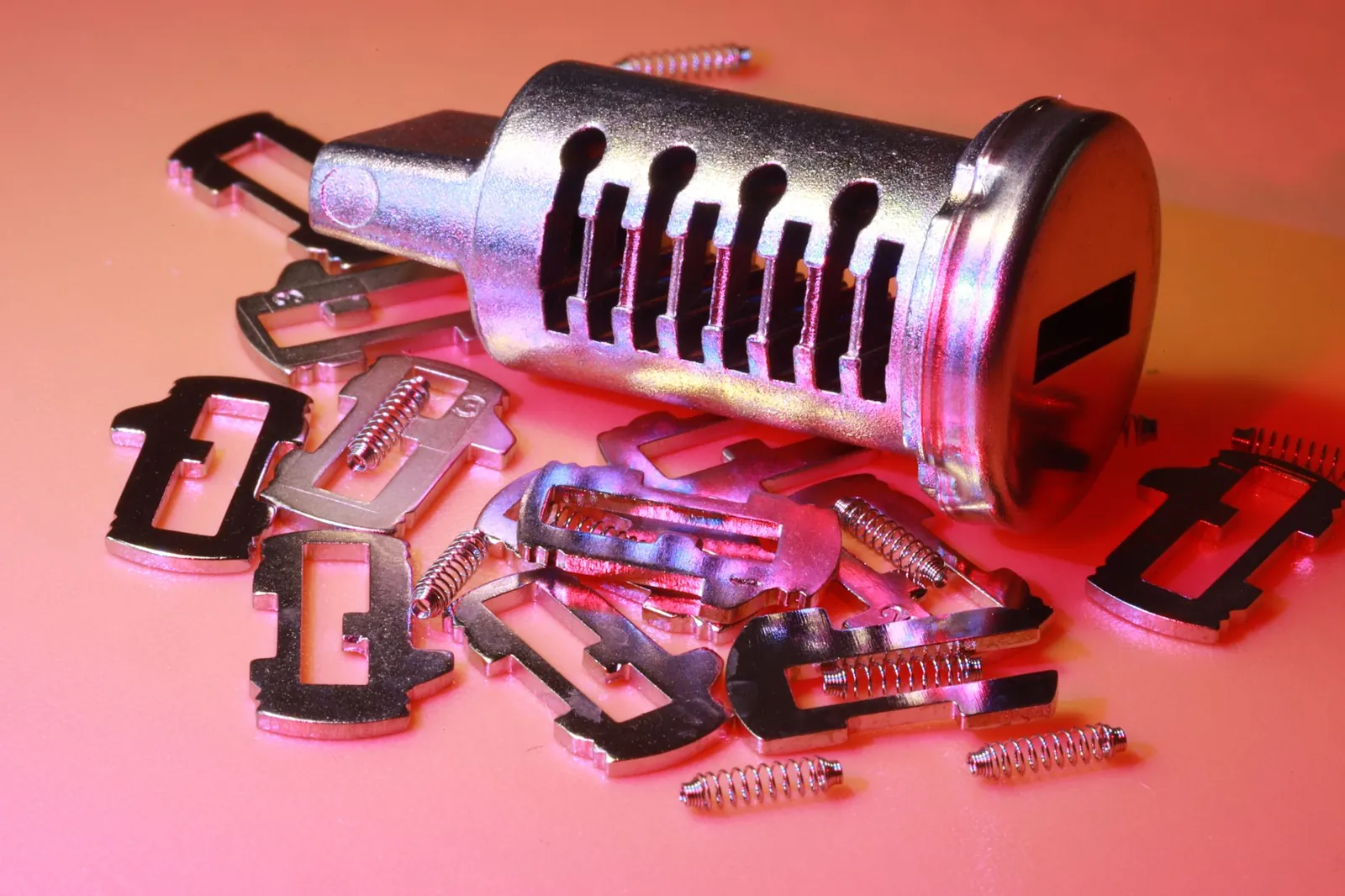Detailed image of a disassembled lock cylinder and its metal components on a colored surface. Stock photo illustrating Goodluck India's fund raise story.