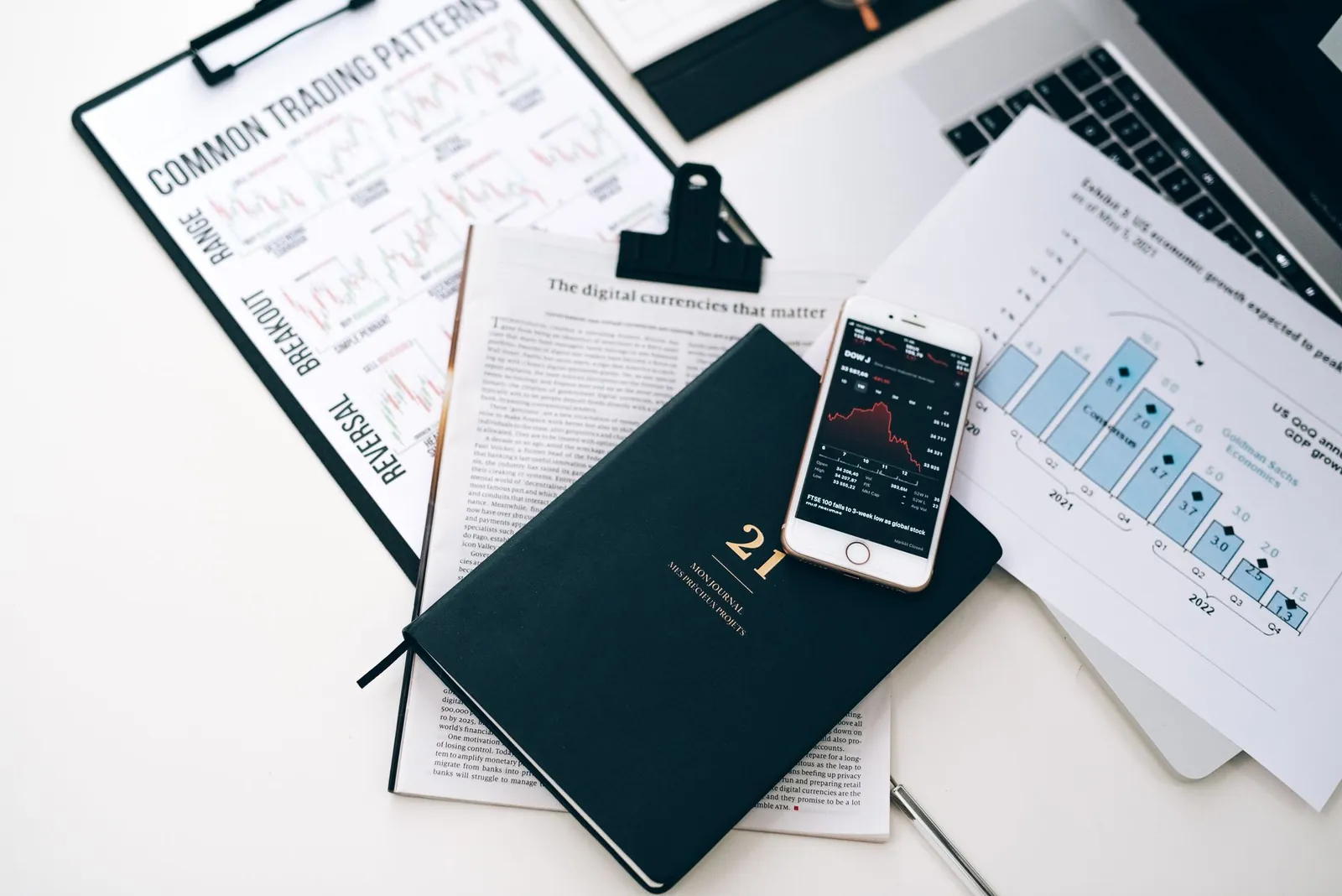 High-angle shot of a stock trading desk with charts, graphs, and a smartphone displaying market trends. Stock photo for the ALFA News guide: Insider Trading Disclosures Under Regulation 7: A SEBI Guide.