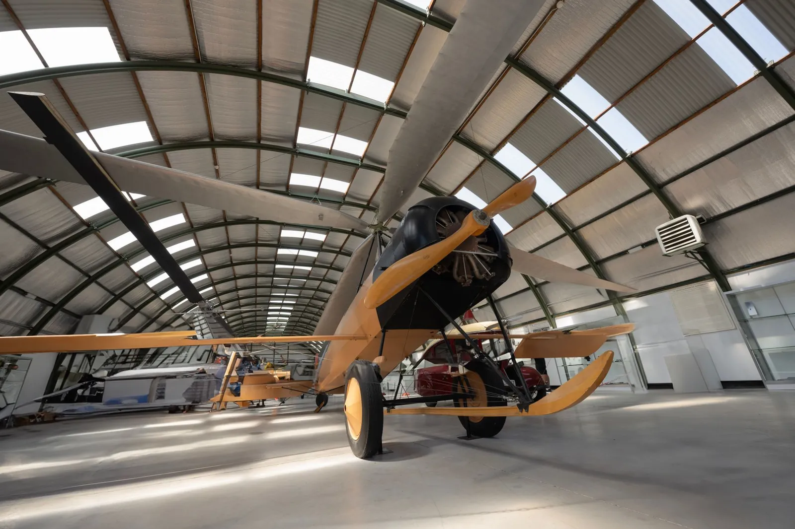 A vintage aircraft displayed in a hangar with an arched roof structure, showcasing aviation history. Stock photo illustrating TechEra Engineering (India)'s new order story.