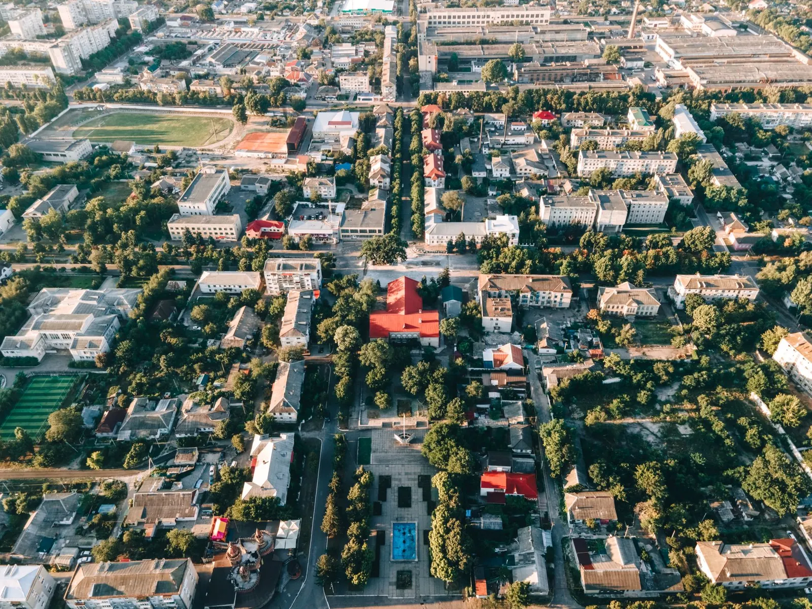 High-angle aerial view of a vibrant urban townscape with buildings and trees. Stock photo illustrating Welspun Corp's new order story.