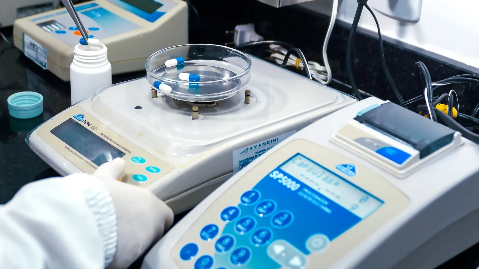 Close-up of laboratory equipment with capsules, capturing pharmaceutical analysis. Stock photo illustrating Qualitek Labs' fund raise story.