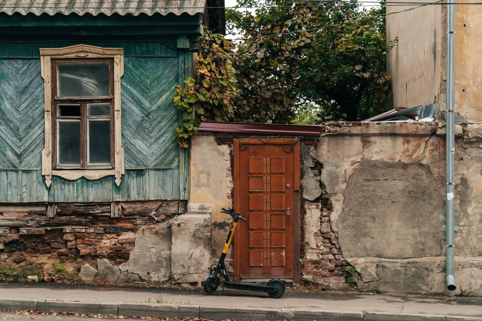 Old wooden building facade with scooter on a rustic street, depicting urban decay and vintage architecture. Stock photo illustrating TVS Motor Company's product launched story.