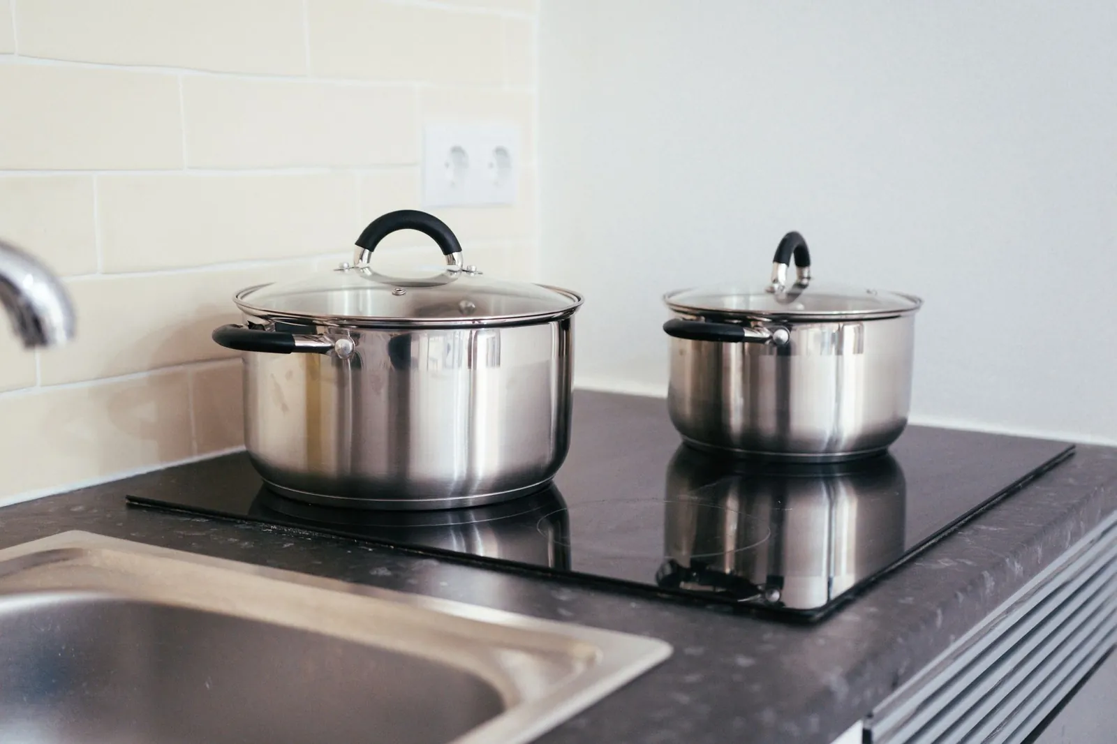 Contemporary kitchen setup with stainless steel pots on an induction stove. Stock photo illustrating Stove Kraft's earning call story.