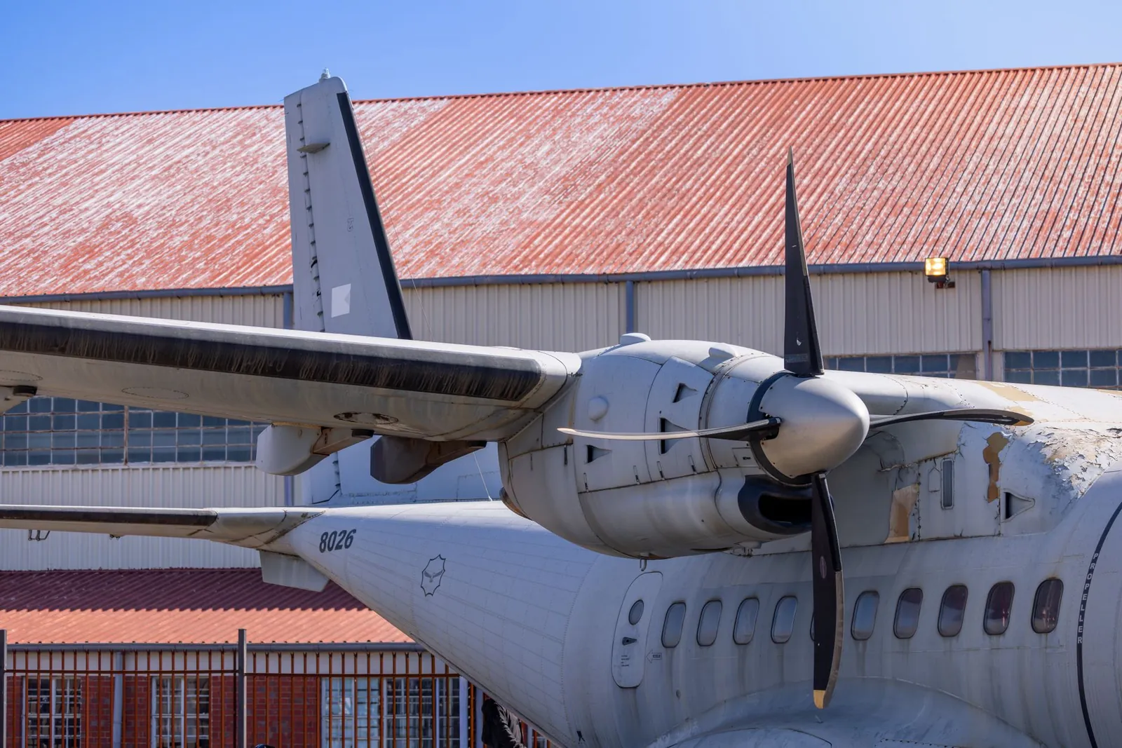 Detailed view of a turboprop engine on an aircraft in front of a hangar under clear blue skies. Stock photo illustrating Premier Explosives' earning call story.