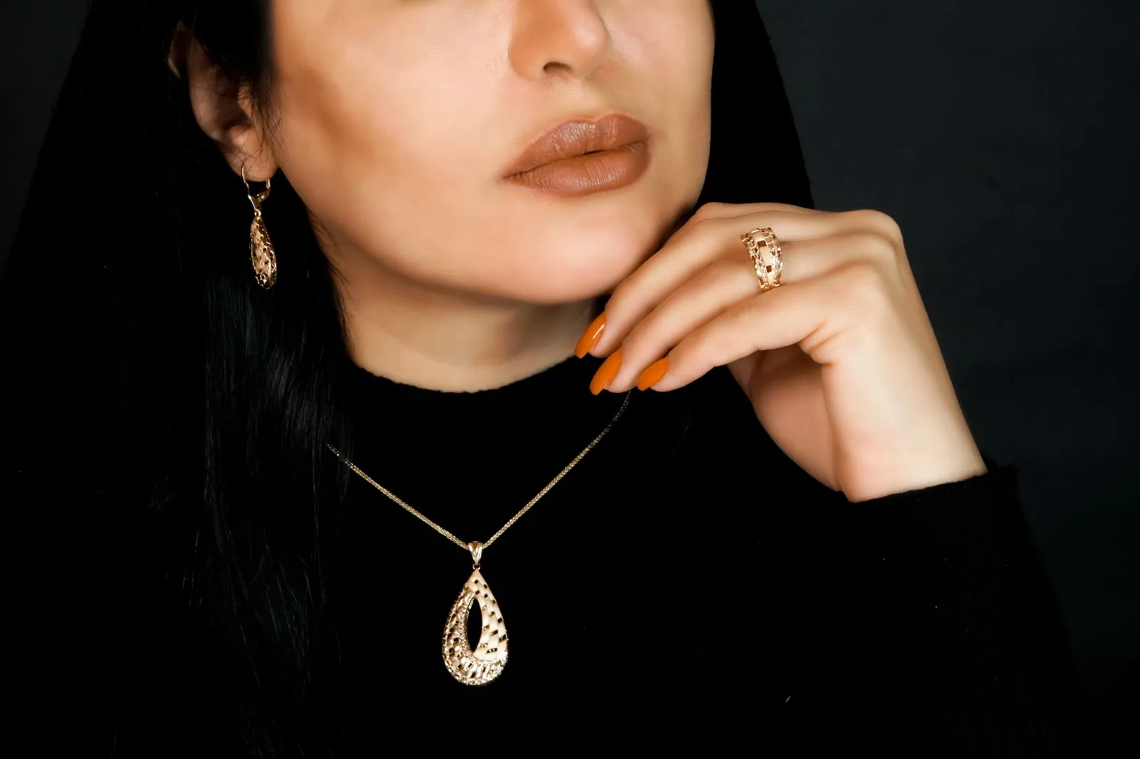 Close-up of a woman adorned in an elegant gold jewelry set, featuring a necklace, earrings, and ring. Stock photo illustrating Utssav CZ Gold Jewels' expansion story.