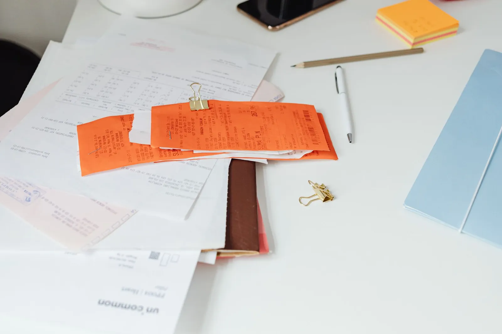 Close-up of a tidy desk with receipts, documents, and office stationery for business organization. Stock photo for the ALFA News guide: How to Read a Shareholding Pattern Filing.