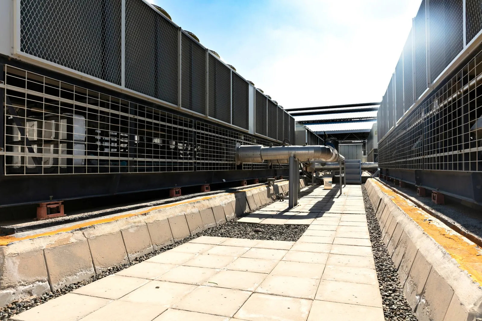 View of a large industrial cooling system with metal pipes and grids outdoors under bright daylight. Stock photo illustrating Kirloskar Pneumatic Company's product launched story.