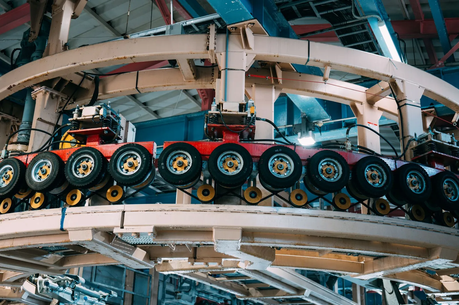 Close-up view of a complex industrial conveyor system inside a manufacturing facility. Stock photo illustrating Wheels India's fund raise story.