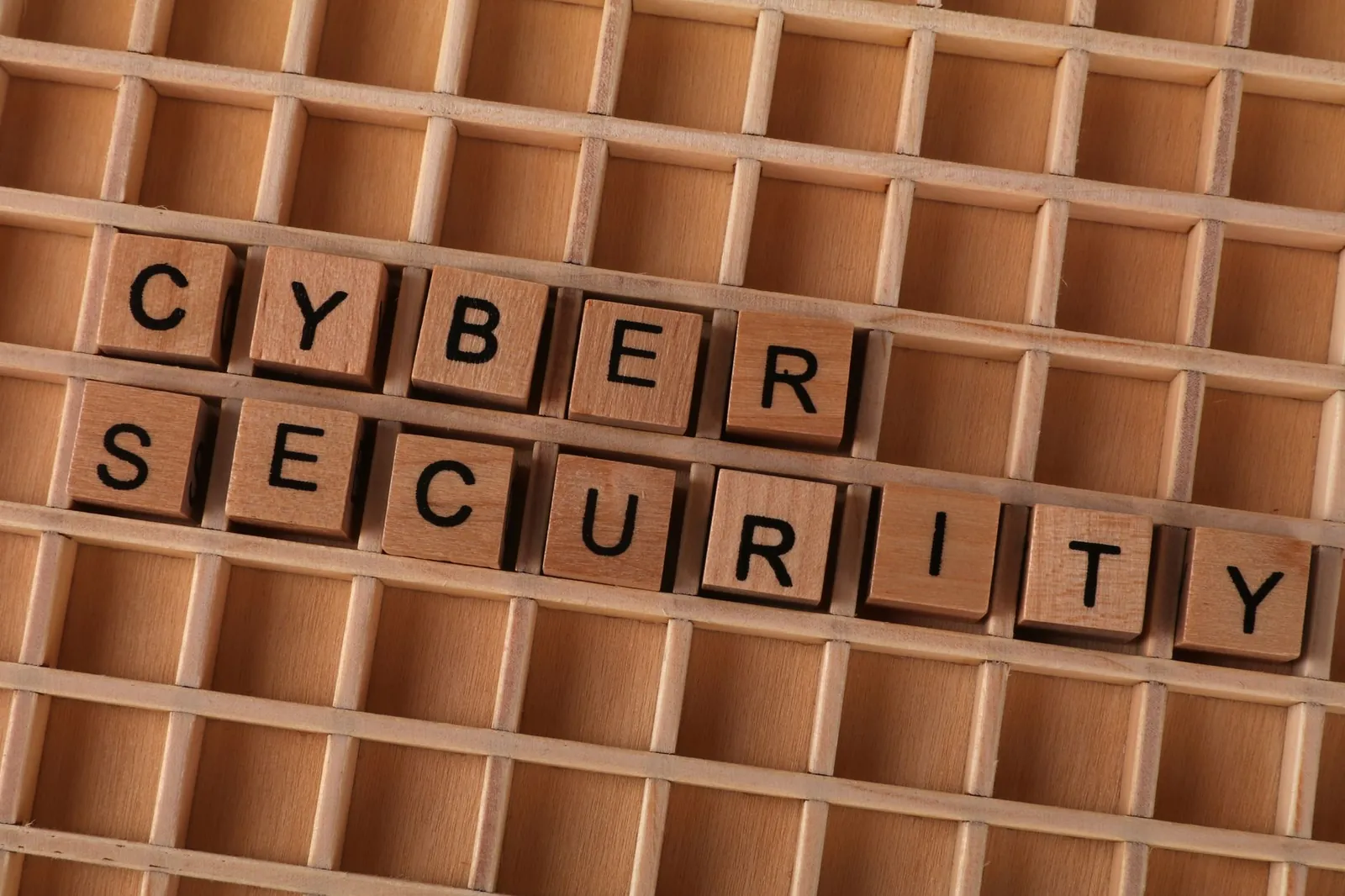Wooden letter blocks spelling 'CYBER SECURITY' on a wooden grid background for data protection themes. Stock photo illustrating TAC Infosec's product launched story.