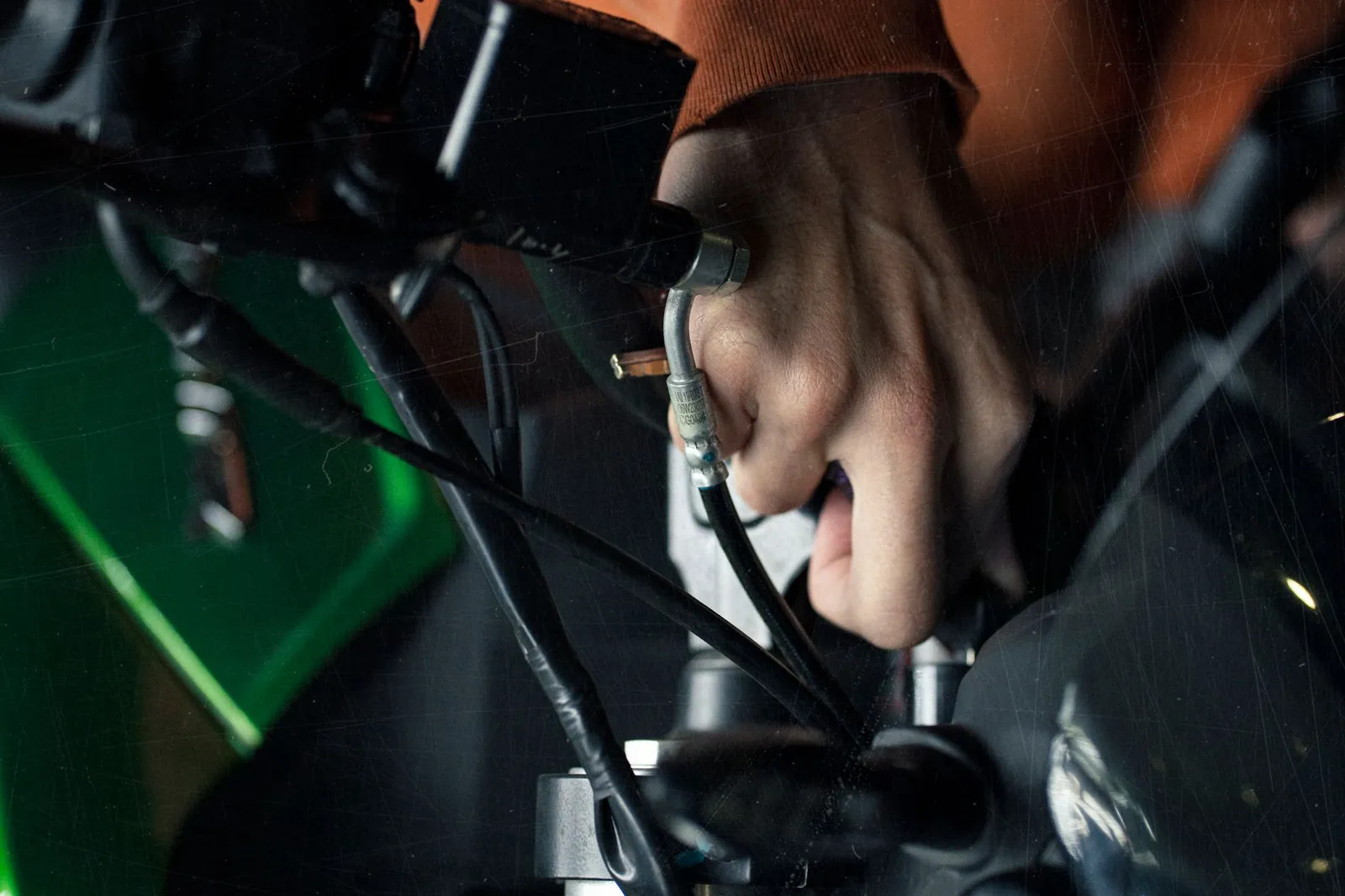 A detailed close-up of a hand adjusting motorcycle cables, showcasing technical maintenance. Stock photo illustrating Suprajit Engineering's new order story.