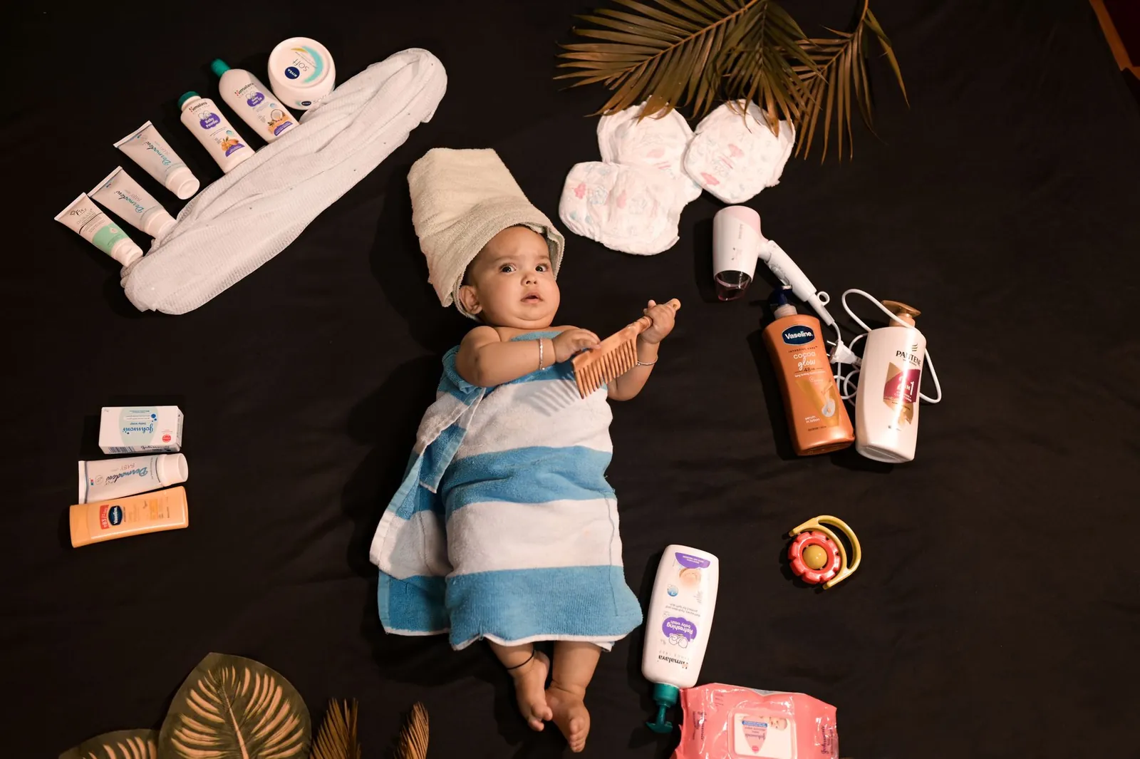 Adorable baby wrapped in towel with skincare essentials. Perfect for beauty and childcare themes. Stock photo illustrating Wanbury's product launched story.