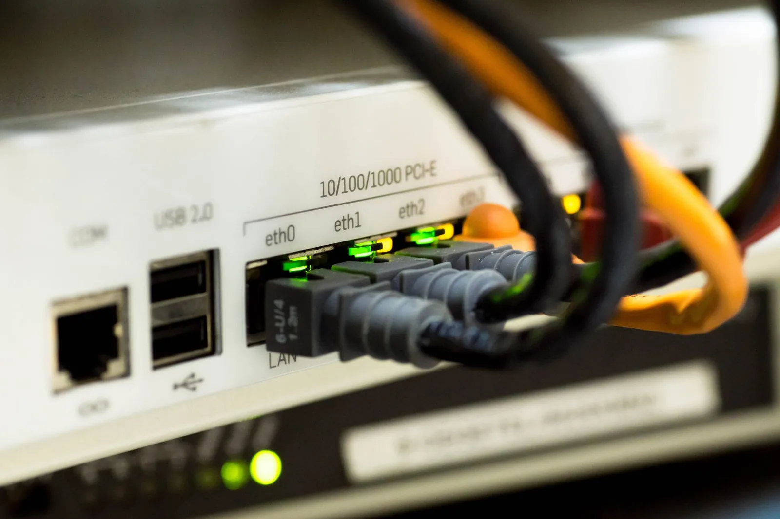 Detailed close-up of ethernet cables and network connections on a router, showcasing modern technology. Stock photo illustrating HFCL's financial results story.
