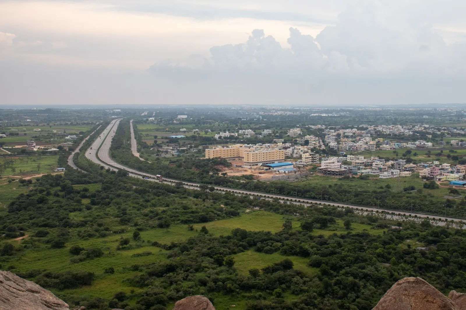 Aerial view of a lush green Indian landscape with a highway stretching through fields and residential areas. Stock photo illustrating SEPC's new order story.